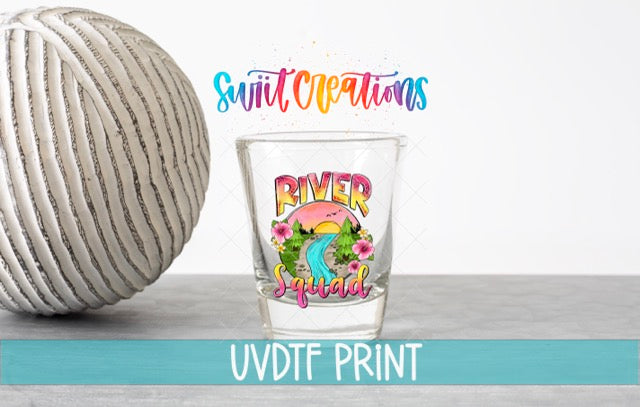 a shot glass next to a ball of yarn