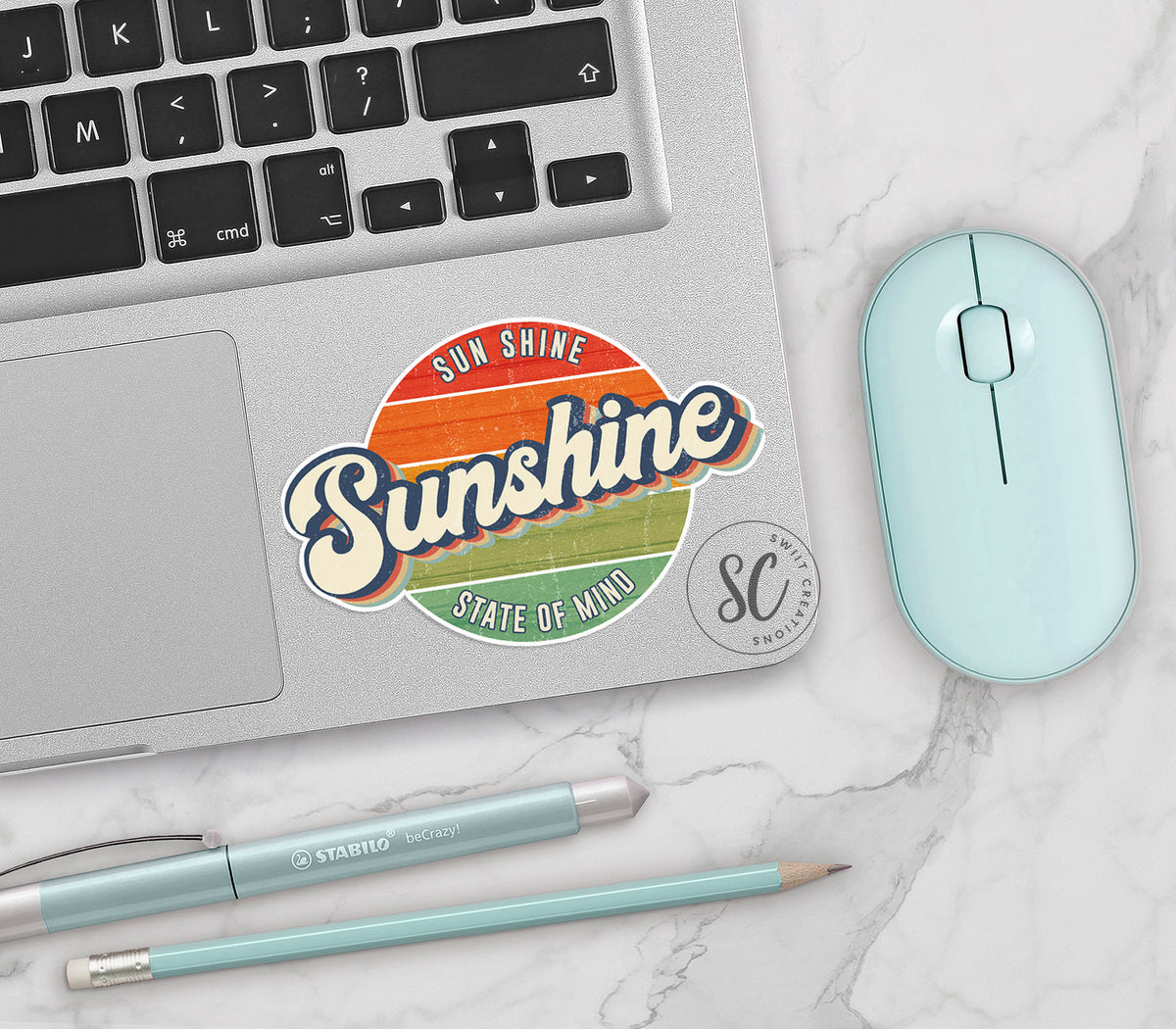 Sunshine State of Mind vinyl sticker on a silver laptop next to a mint mouse and pens