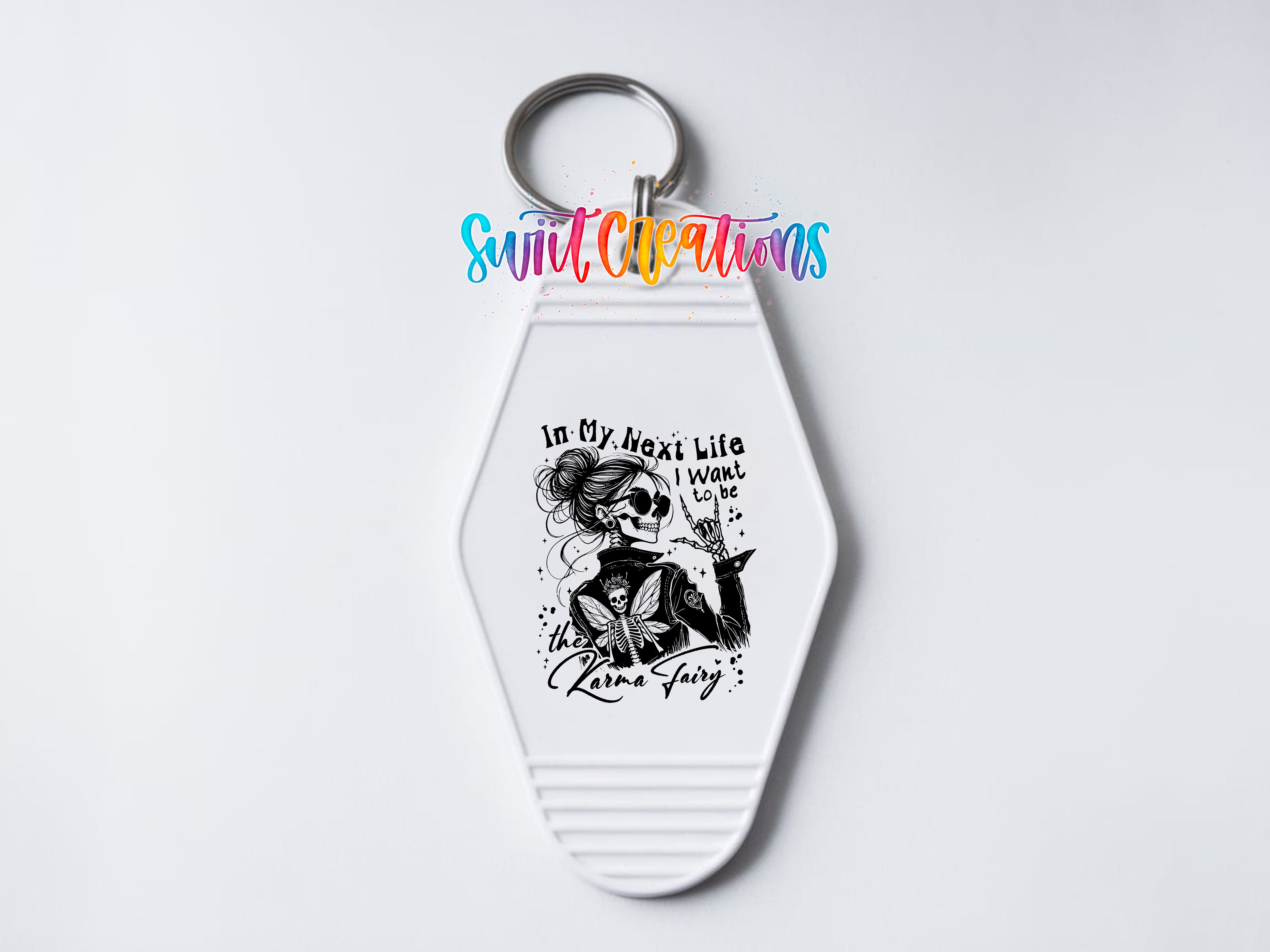 A keychain with a stylized illustration of a woman and text that reads "In my next life I want to be a unicorn fairy".