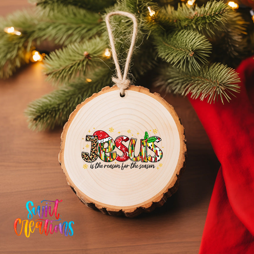 A wooden ornament with the word "JESUS" written on it, hanging on a Christmas tree.
