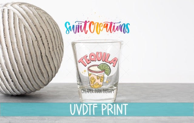 a ball of yarn next to a shot glass