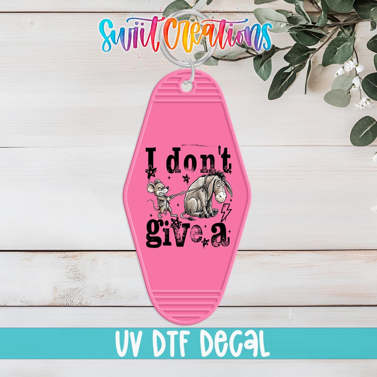 A pink keychain with a cartoon image of Eeyore and the text "I don't give a" printed on it, along with the text "UV Dtf Decal" at the bottom.