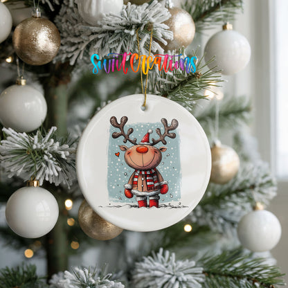 A white Christmas tree decorated with ornaments, including a ceramic ornament featuring a cartoon reindeer.