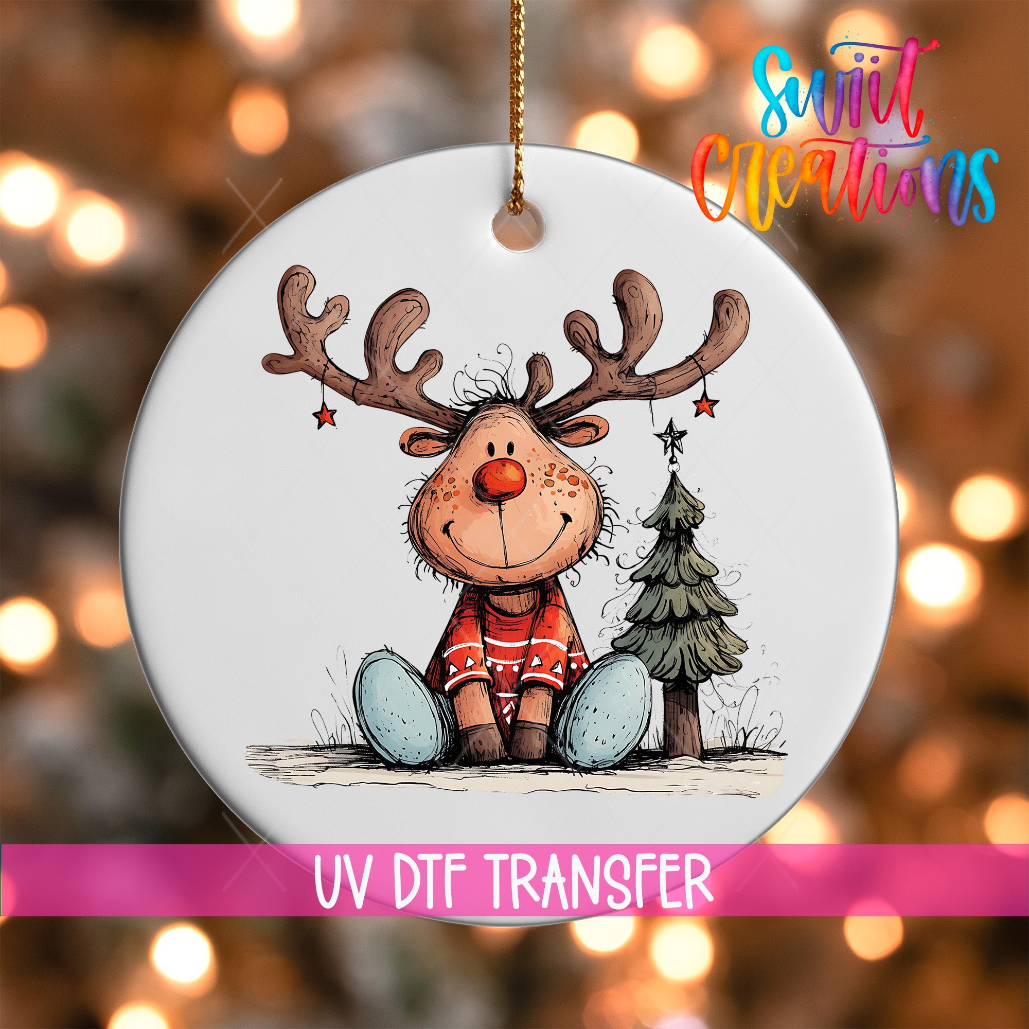 A white ornament featuring a cartoon reindeer with antlers and a star, sitting next to a Christmas tree.