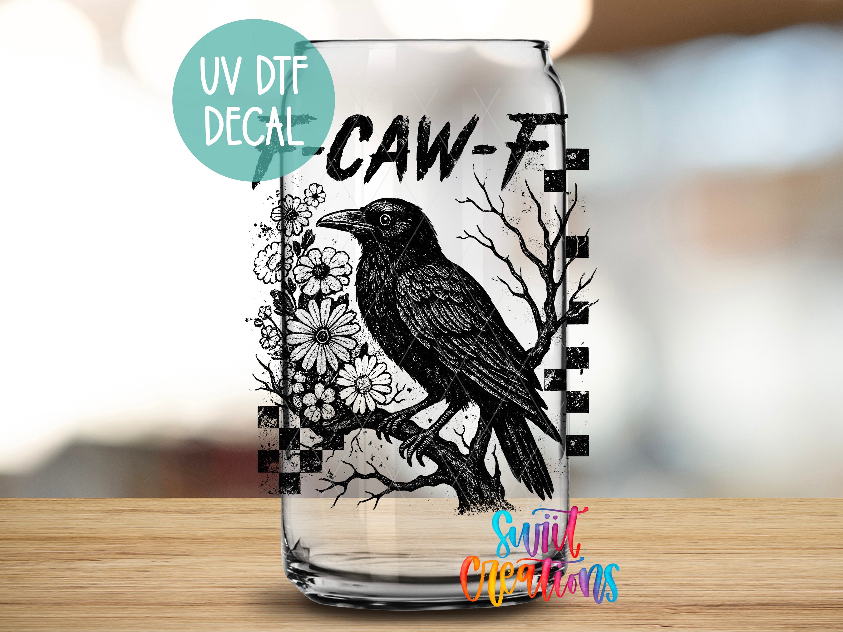 A glass can with a black and white illustration of a crow and flowers on it, along with the text "CAW-F" and "UV Dtf Decal".