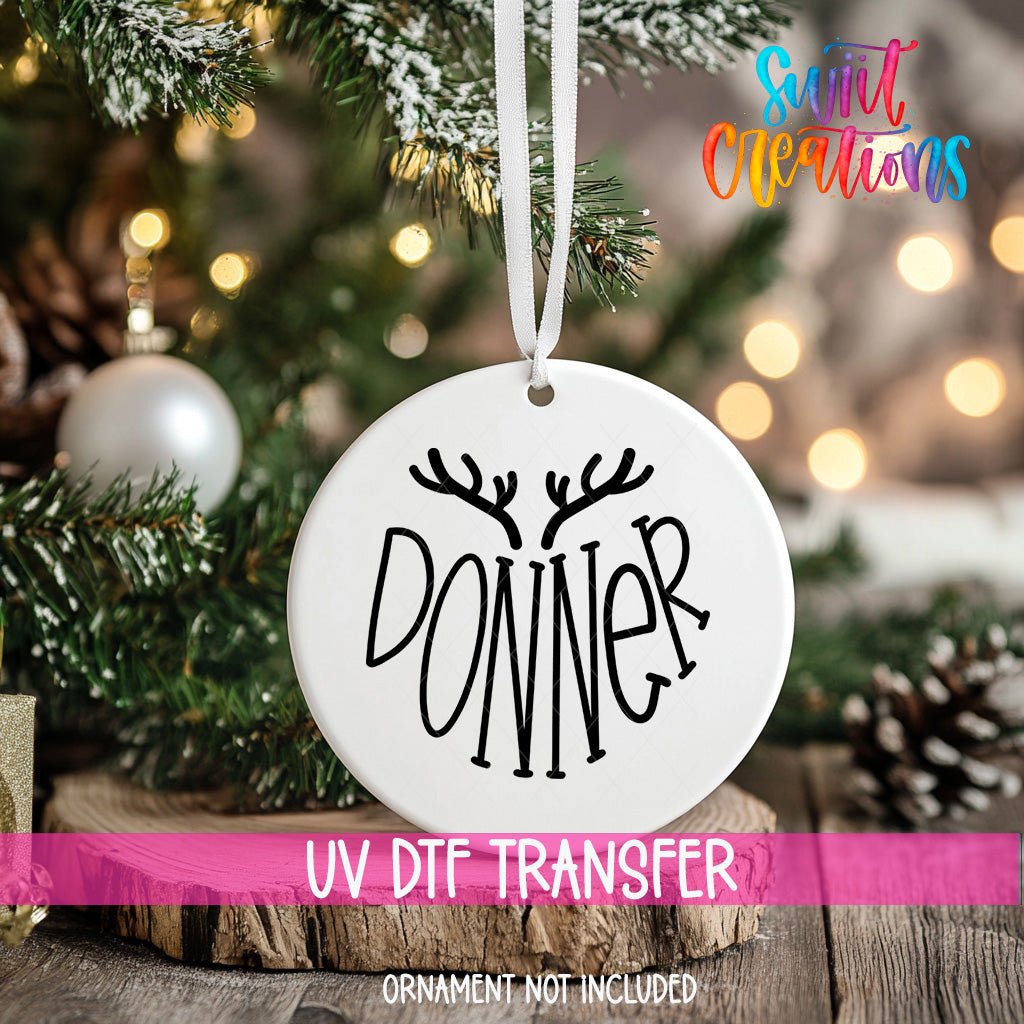 A white ornament with the word "DONNER" written on it, hanging on a Christmas tree.