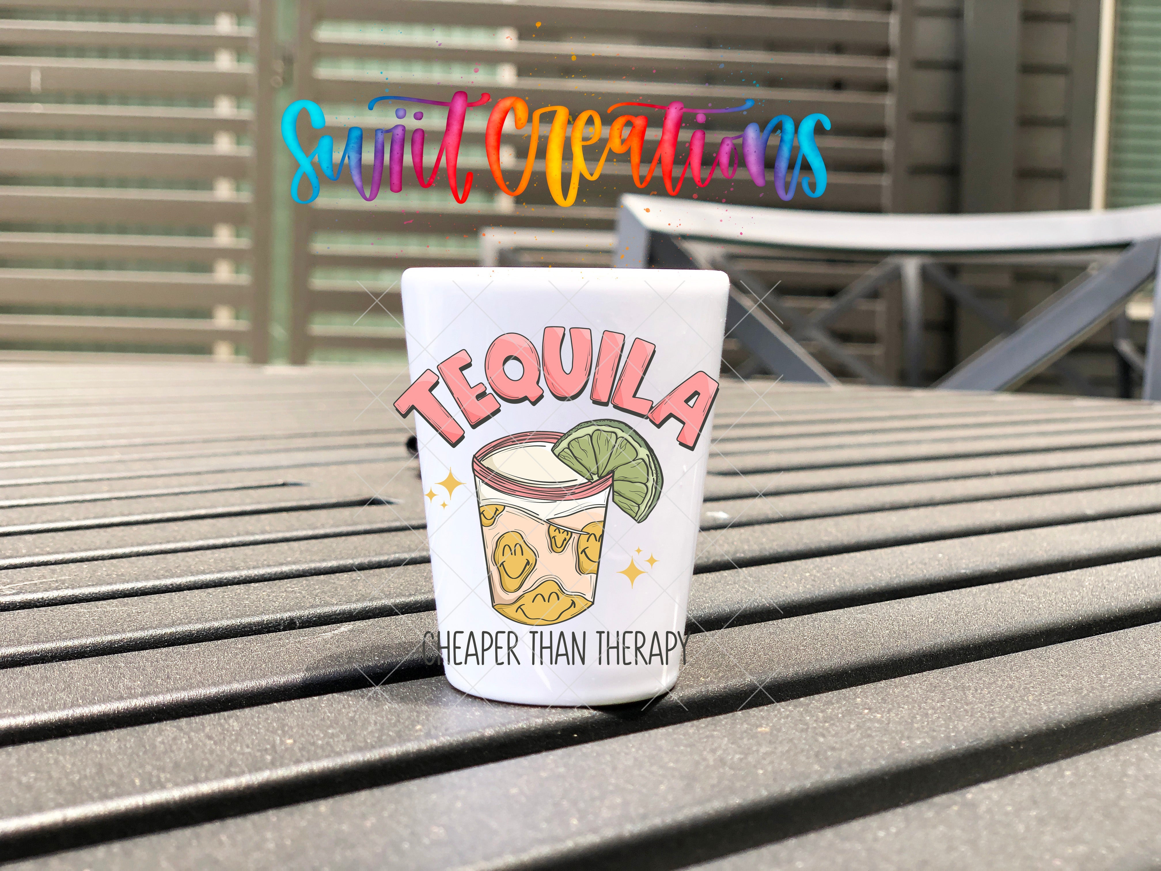 a cup of tequila sitting on top of a wooden table