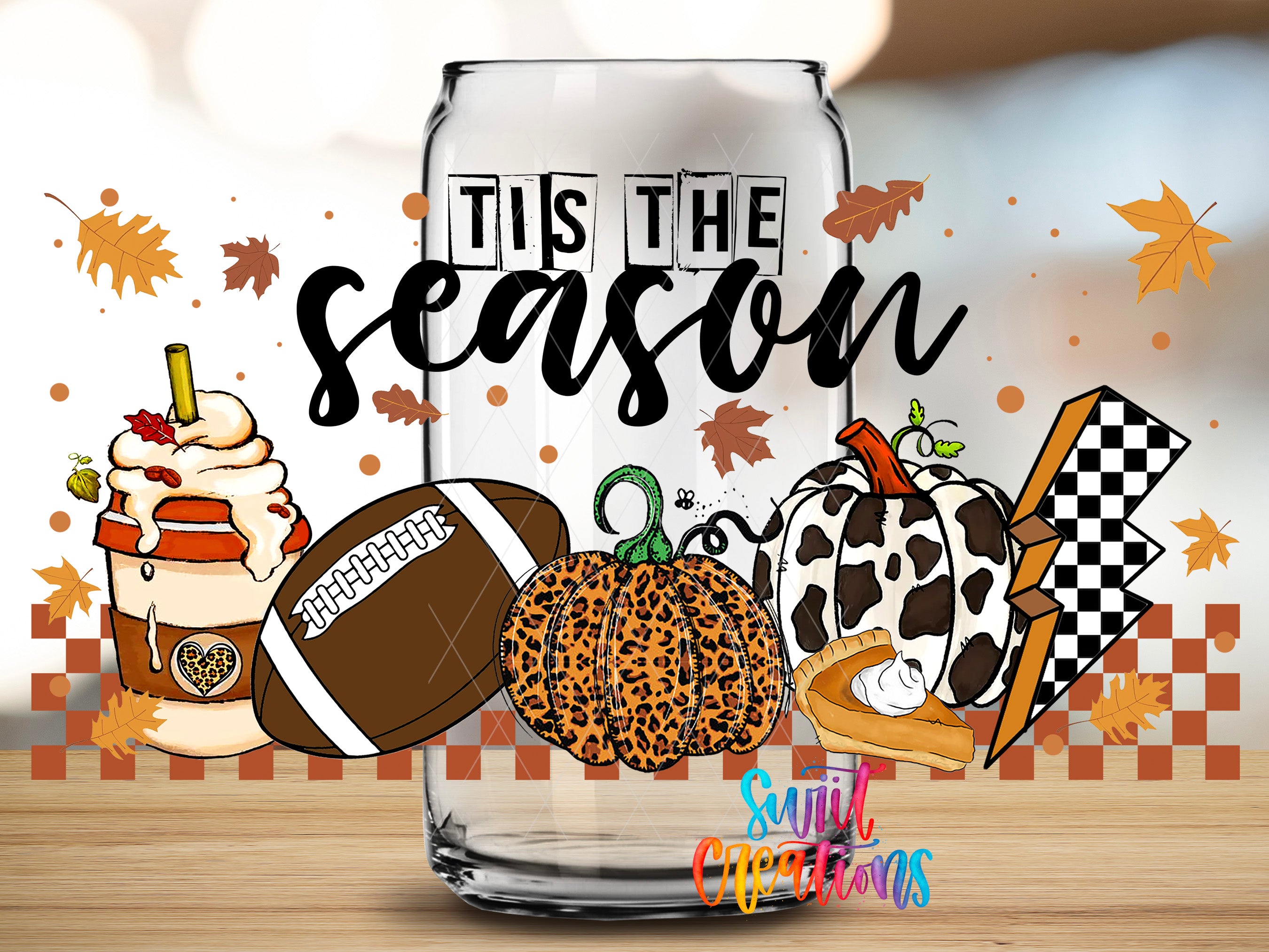 A glass with a football and other fall-themed items, along with the text "Tis the season" written on it, is surrounded by autumn leaves and a checkered pattern.