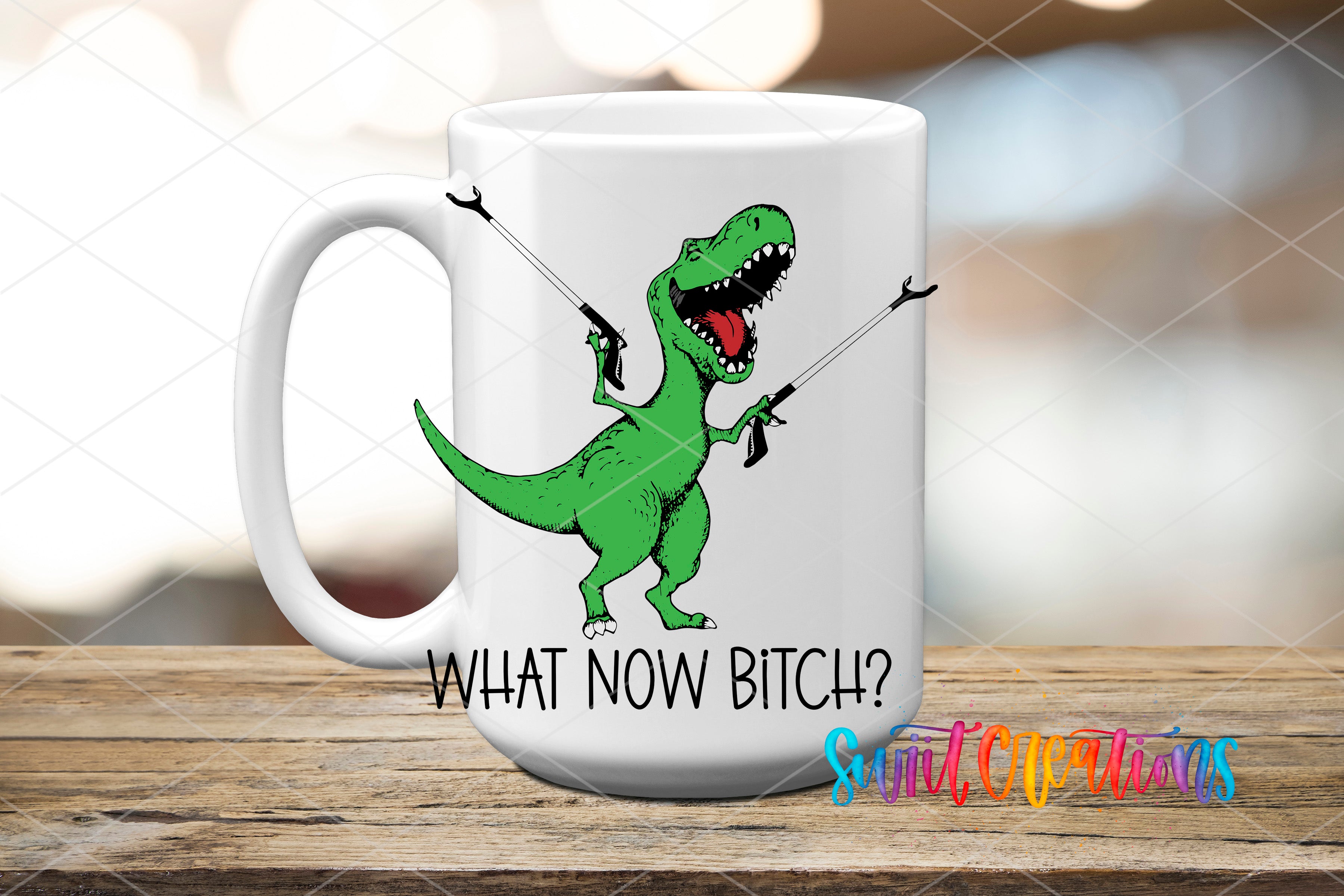 A white ceramic mug with a cartoon image of a green dinosaur holding a gun and the text "WHAT NOW BITCH?" printed on it.