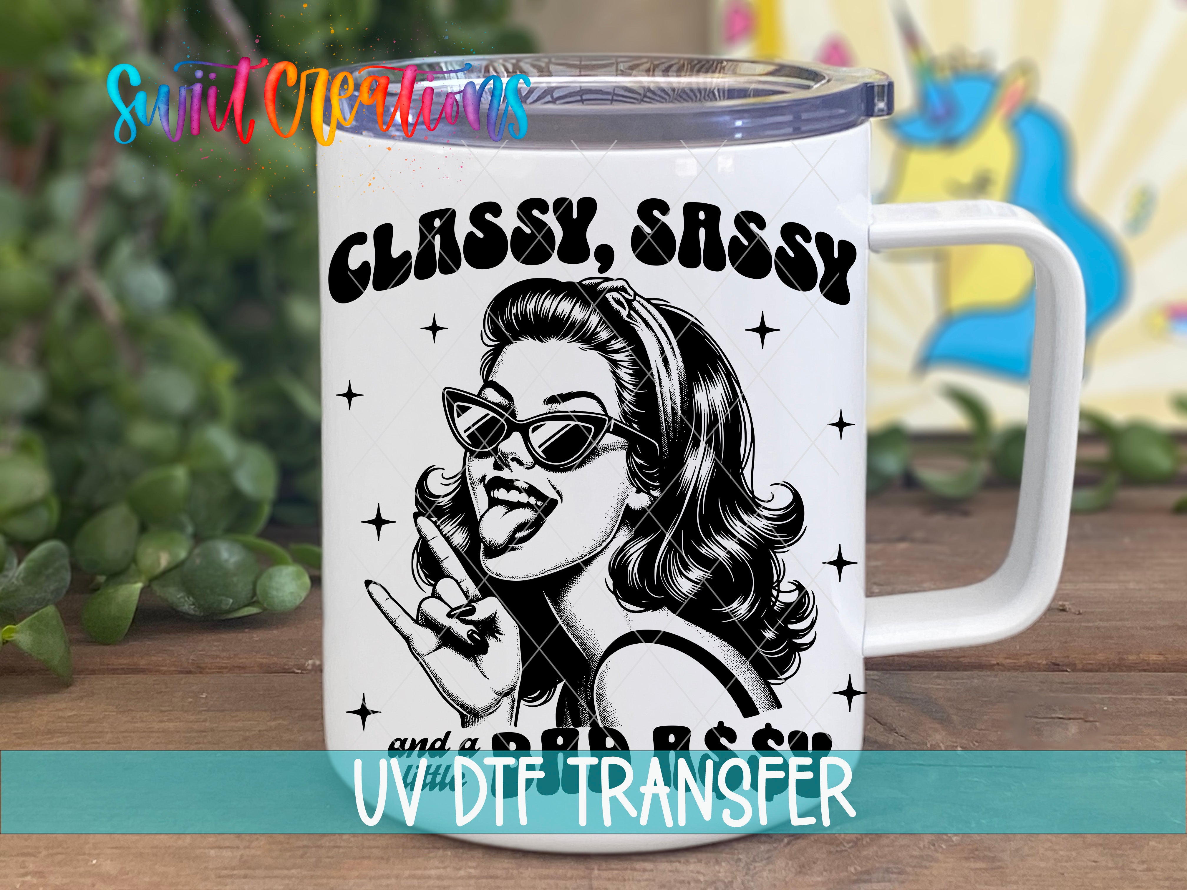 A white mug with a black and white illustration of a woman wearing sunglasses and a sassy expression, along with the text "CLASSY, SASSY and a BAD ASS".