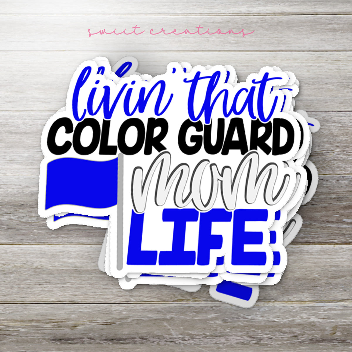 Stack of Livin' That Color Guard Mom Life glossy stickers on a gray wood table
