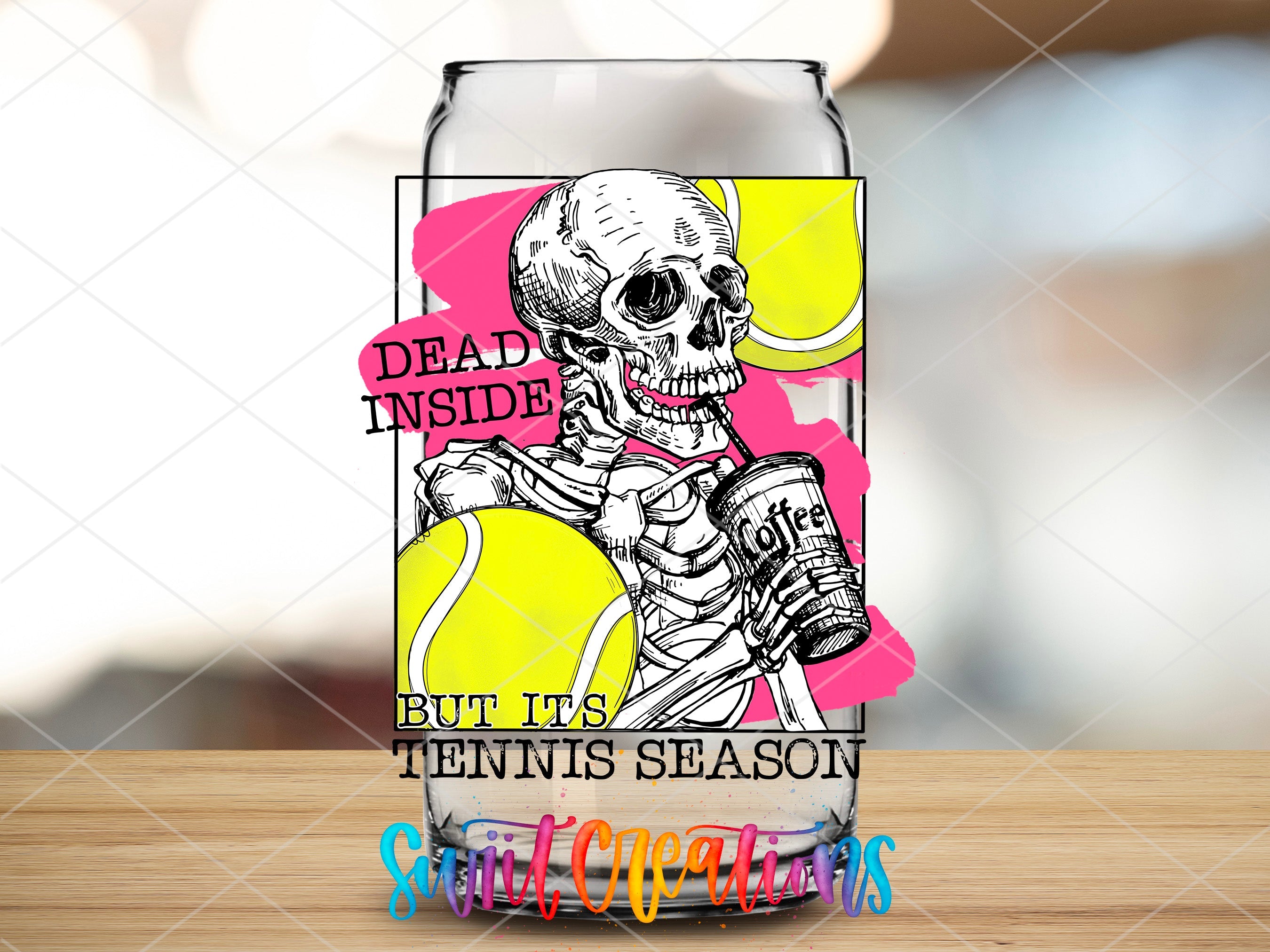 a glass with a picture of a skeleton holding a tennis ball
