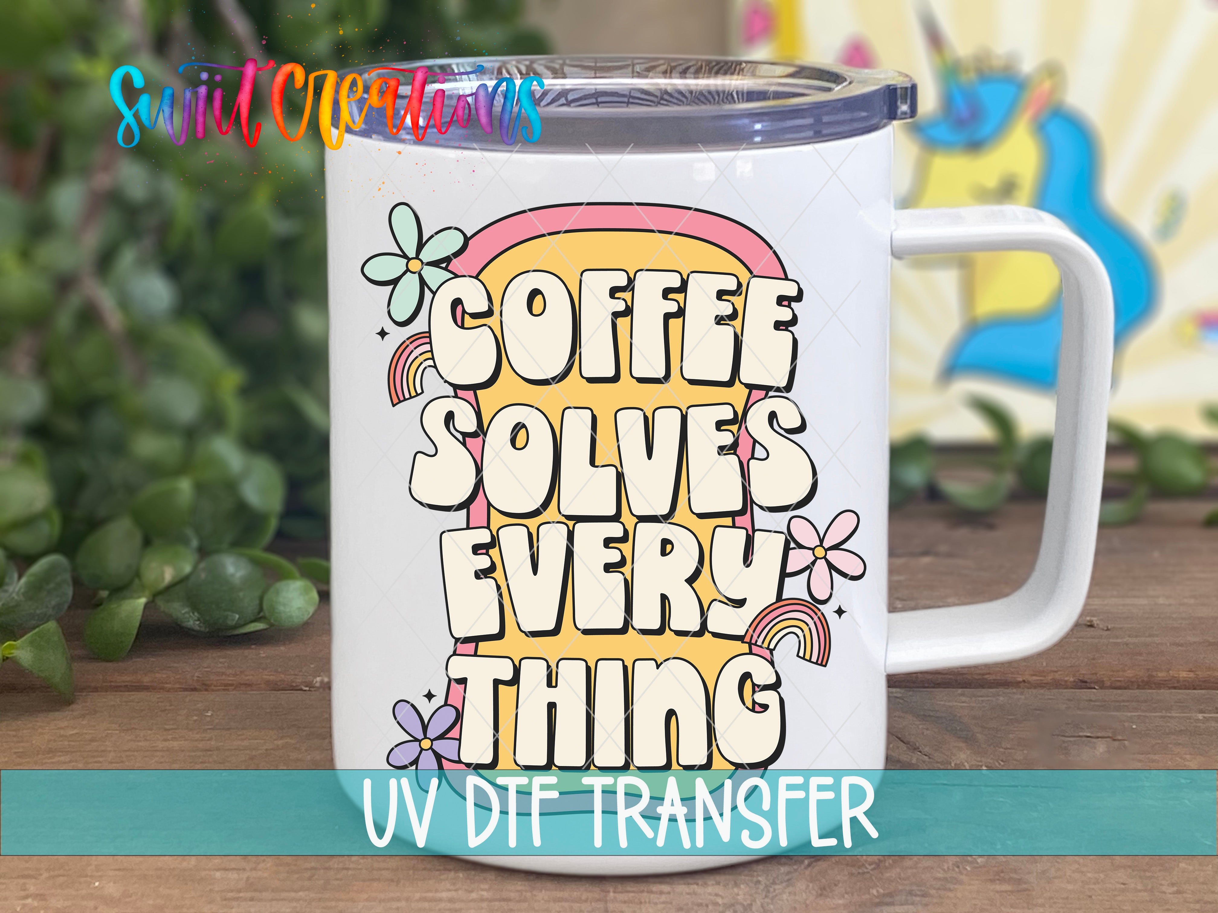 A white mug with a colorful design featuring the text "COFFEE SOLVES EVERY THING" and various decorative elements such as flowers and rainbows.