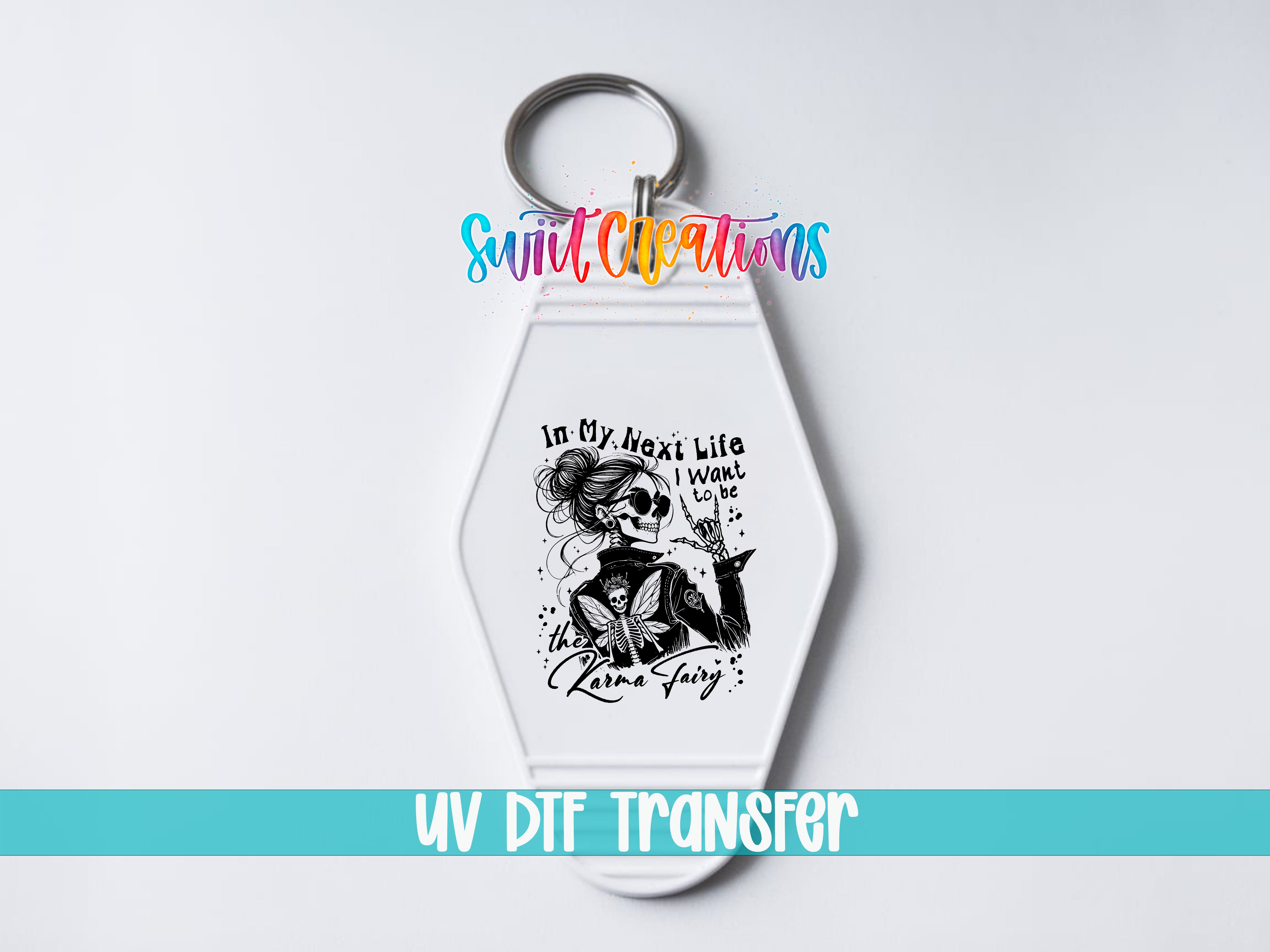 A keychain with a graphic design featuring a woman with a skull-like face and text that reads "In my next life I want to be a unicorn fairy".