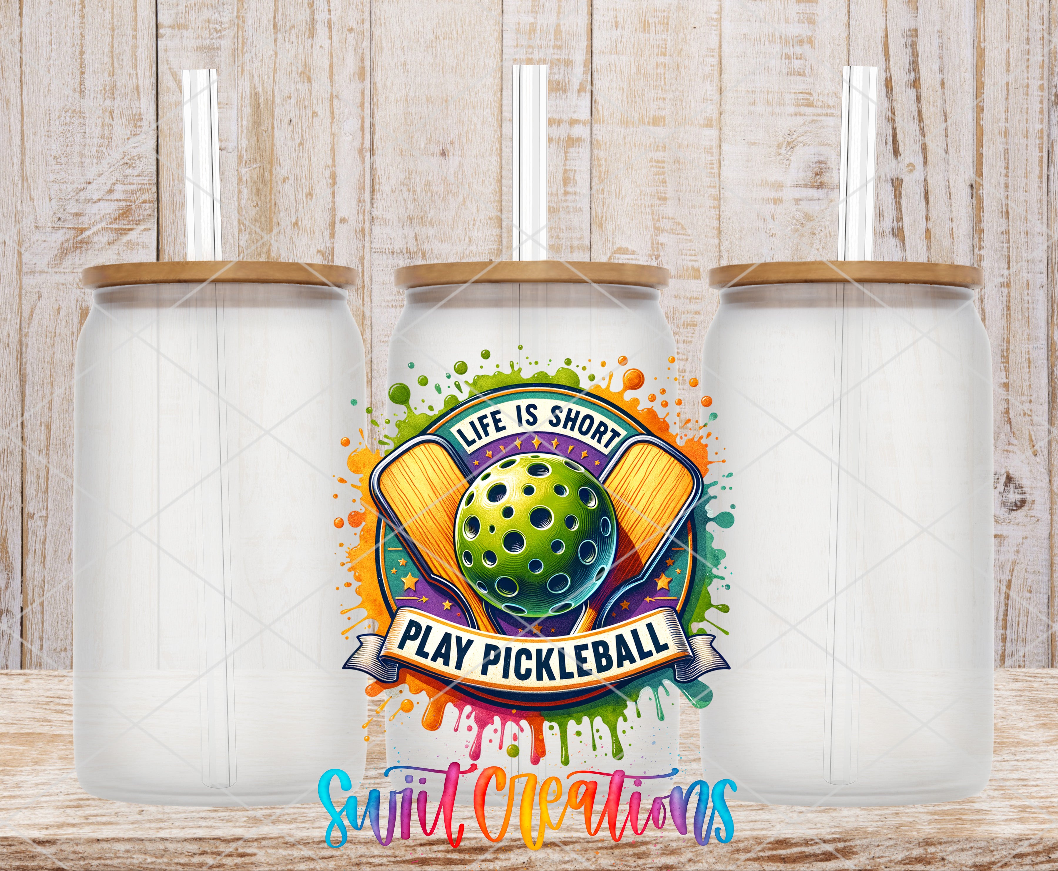 three glass jars with lids, each containing a straw, and a colorful graphic design in the center that says "Life is short, play pickleball" with a tennis racket and a green ball.