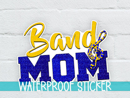 Gold and Blue Band Mom sticker on a white brick background with a waterproof sticker banner