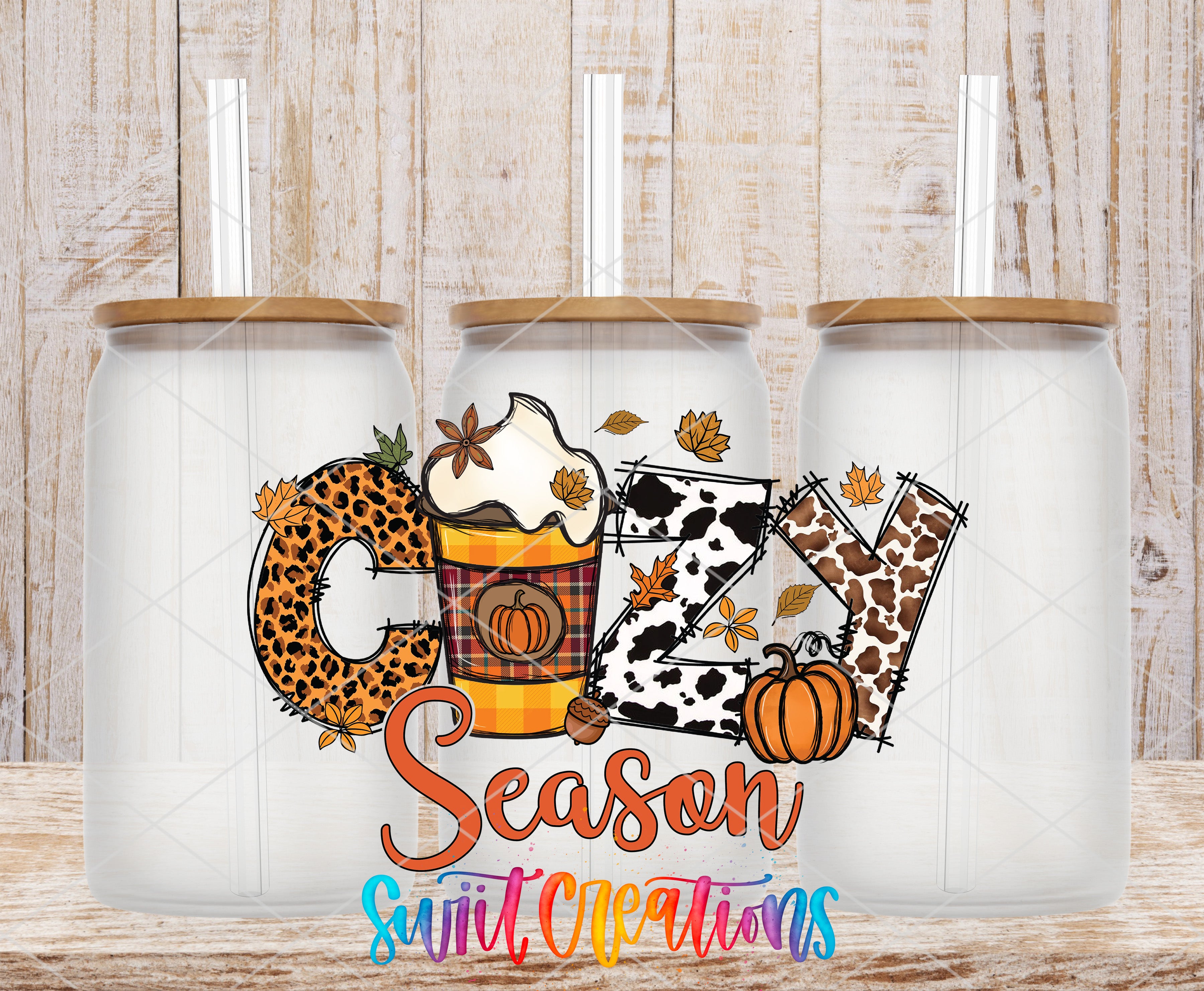 three glass jars with a seasonal design, including a leopard print pattern, a pumpkin, and autumn leaves. The jars have straws on top, and the design includes the word "Cuddle" and the phrase "Season Sweet Creations".