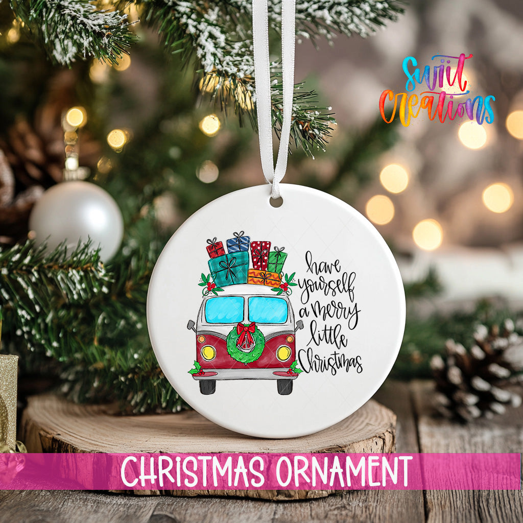 A white Christmas ornament with a red and white van decorated with presents and a wreath, hanging on a tree.