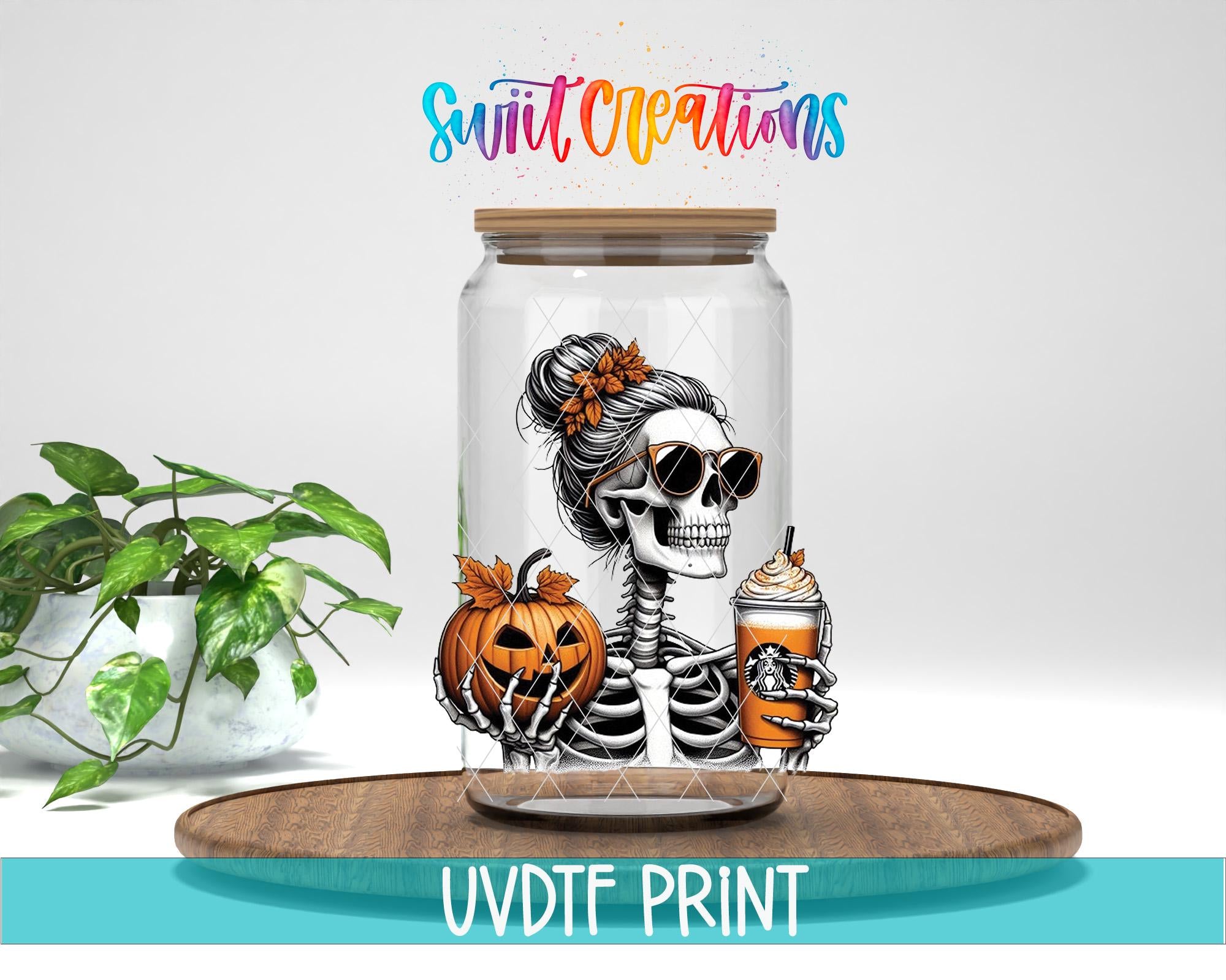 a glass jar with a skeleton wearing sunglasses and holding a pumpkin and a drink, placed on a wooden surface.