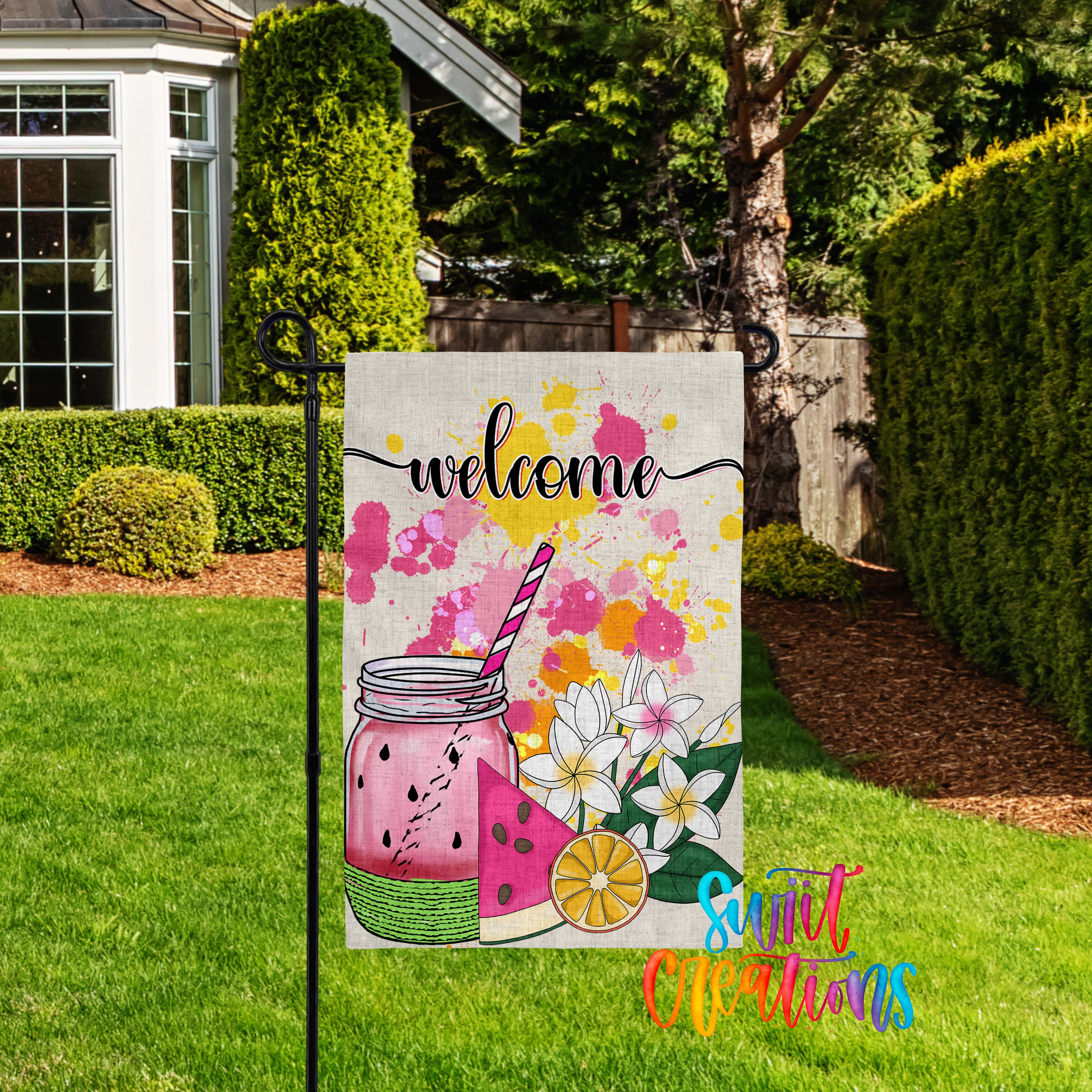 A colorful welcome sign with a mason jar and watermelon slice, set against a backdrop of lush greenery and a house.