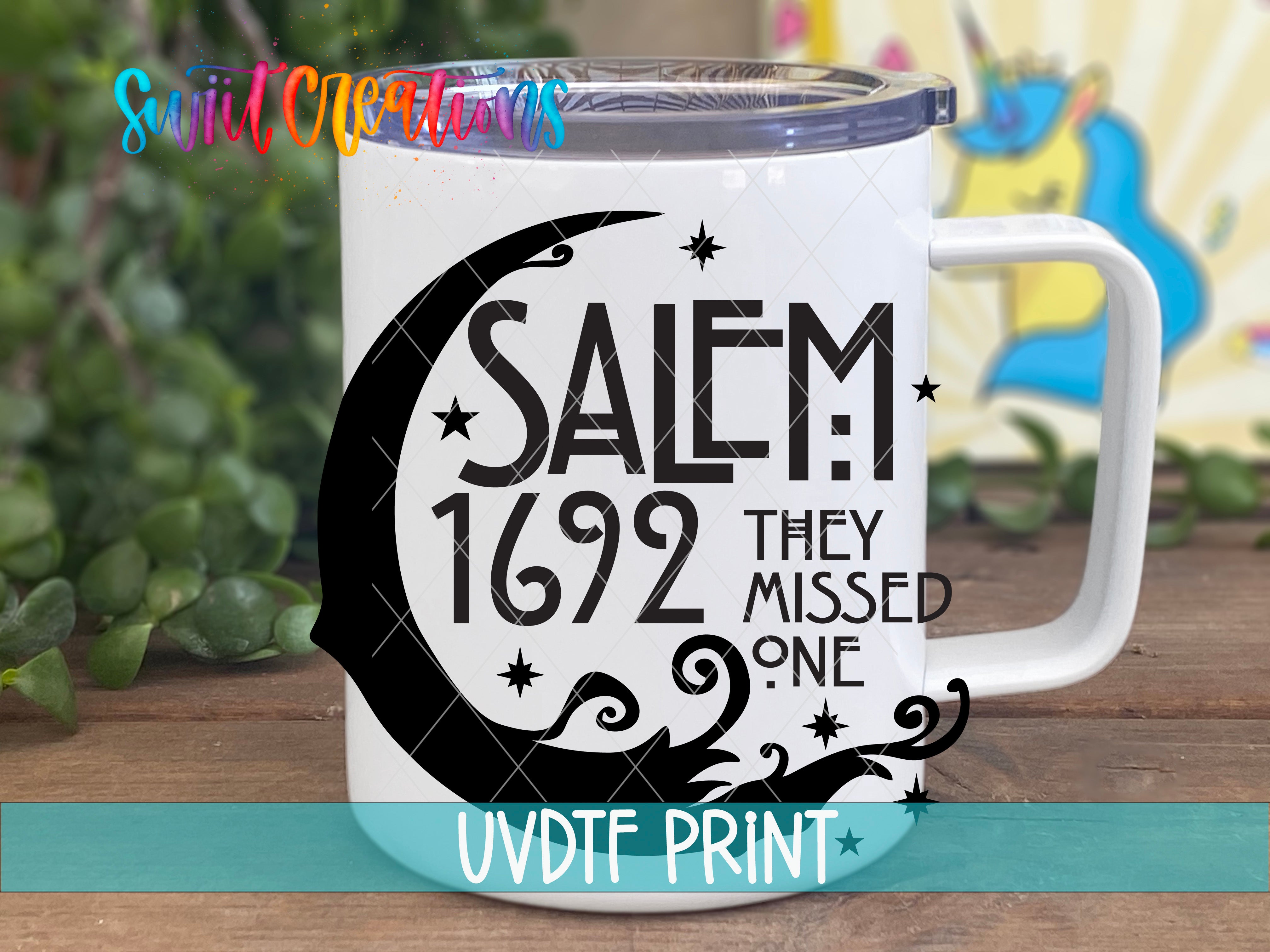 A white mug with a black design featuring the text "SALEM 1692 THEY MISSED ONE" and a crescent moon.