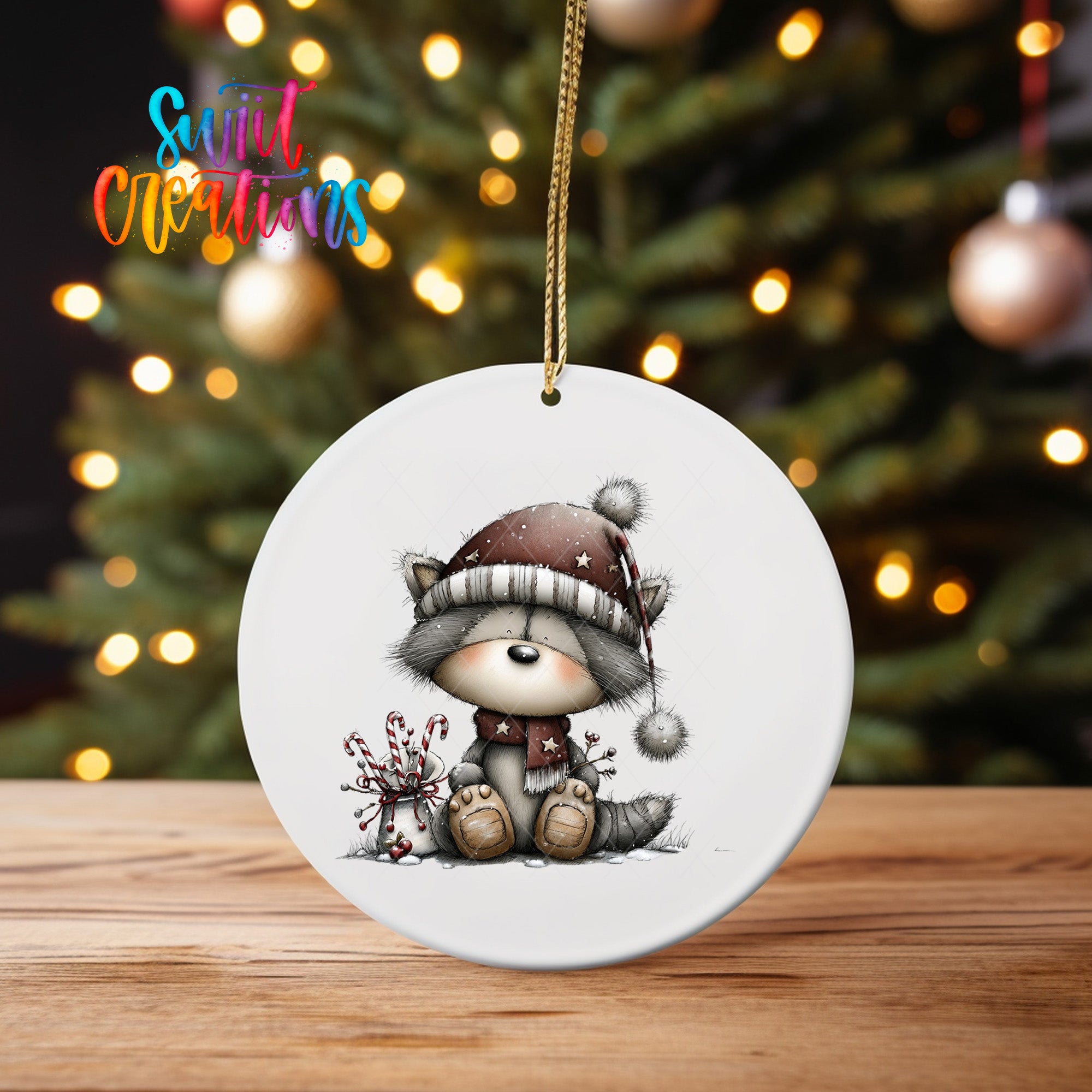 A white ceramic ornament featuring a cartoon raccoon wearing a hat and scarf, sitting on a wooden surface with a blurred background of Christmas lights.