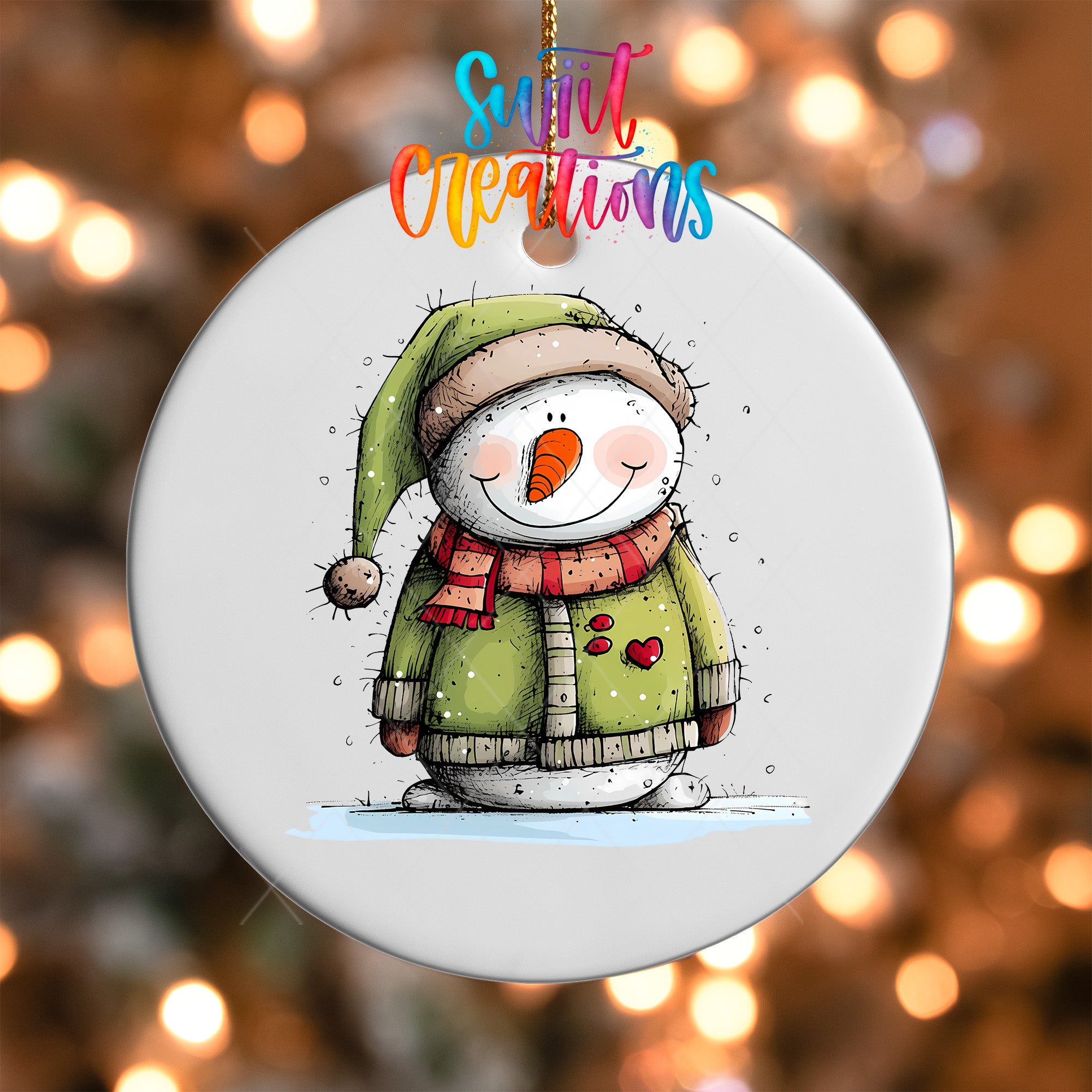 A snowman ornament with a green hat and scarf, and a red heart on its chest, is hanging against a background of colorful lights.