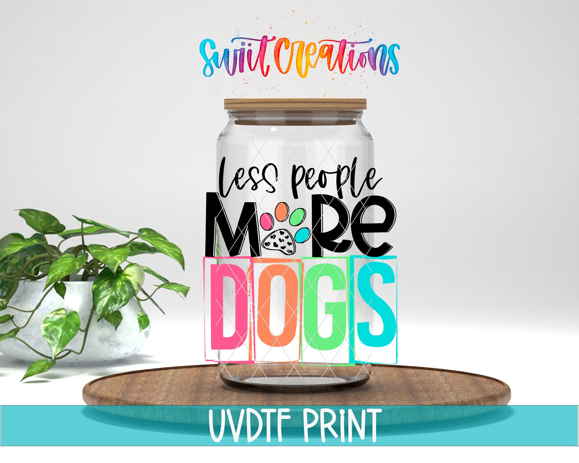 A jar with a lid, featuring a colorful and playful design with the text "Less people, more dogs" and a paw print. The jar is placed on a wooden surface, and there is a potted plant in the background.