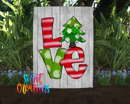 A wooden sign with the word "Love" written on it, featuring a Christmas tree design.