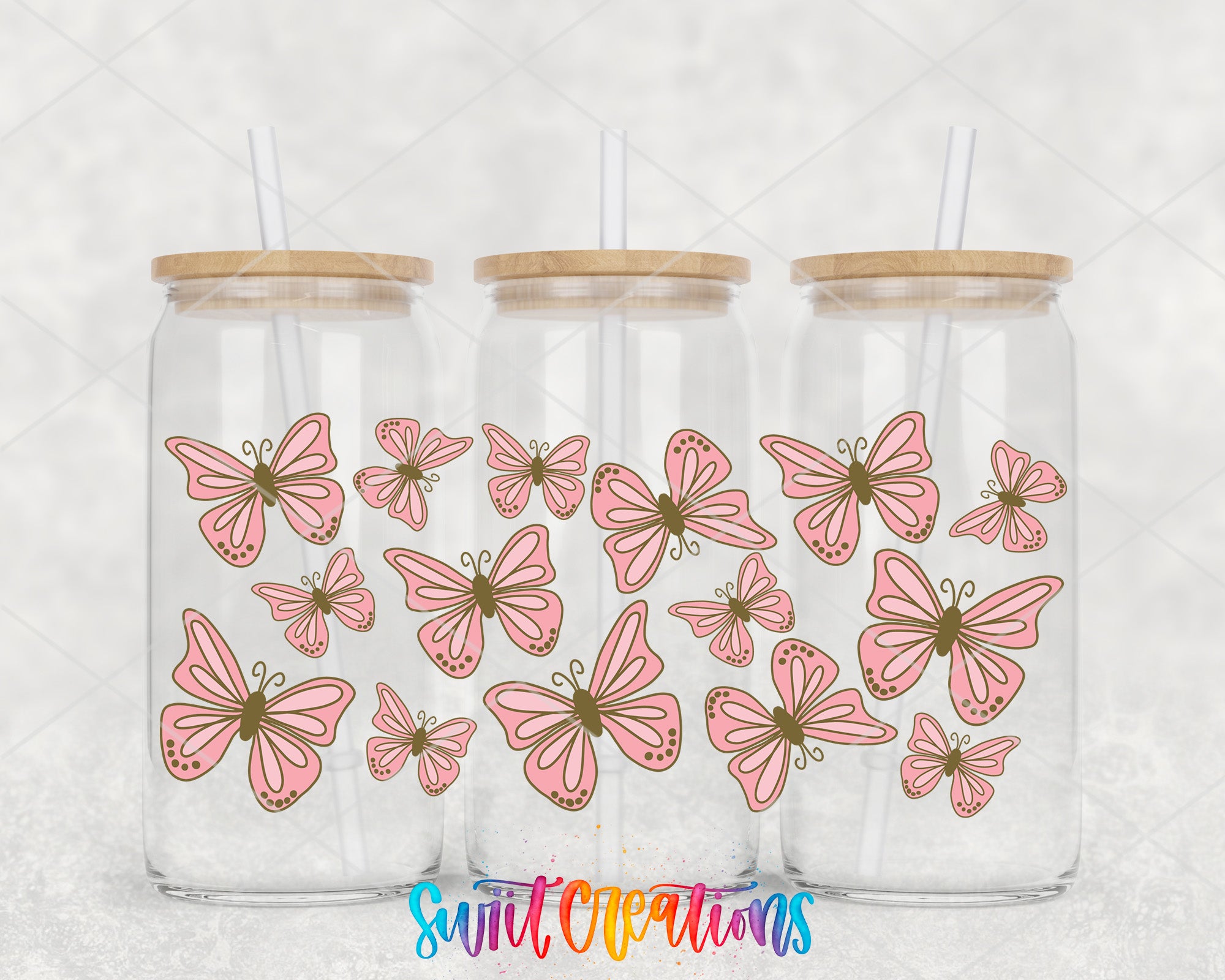 Three glass jars with wooden lids, each containing a pink butterfly design.
