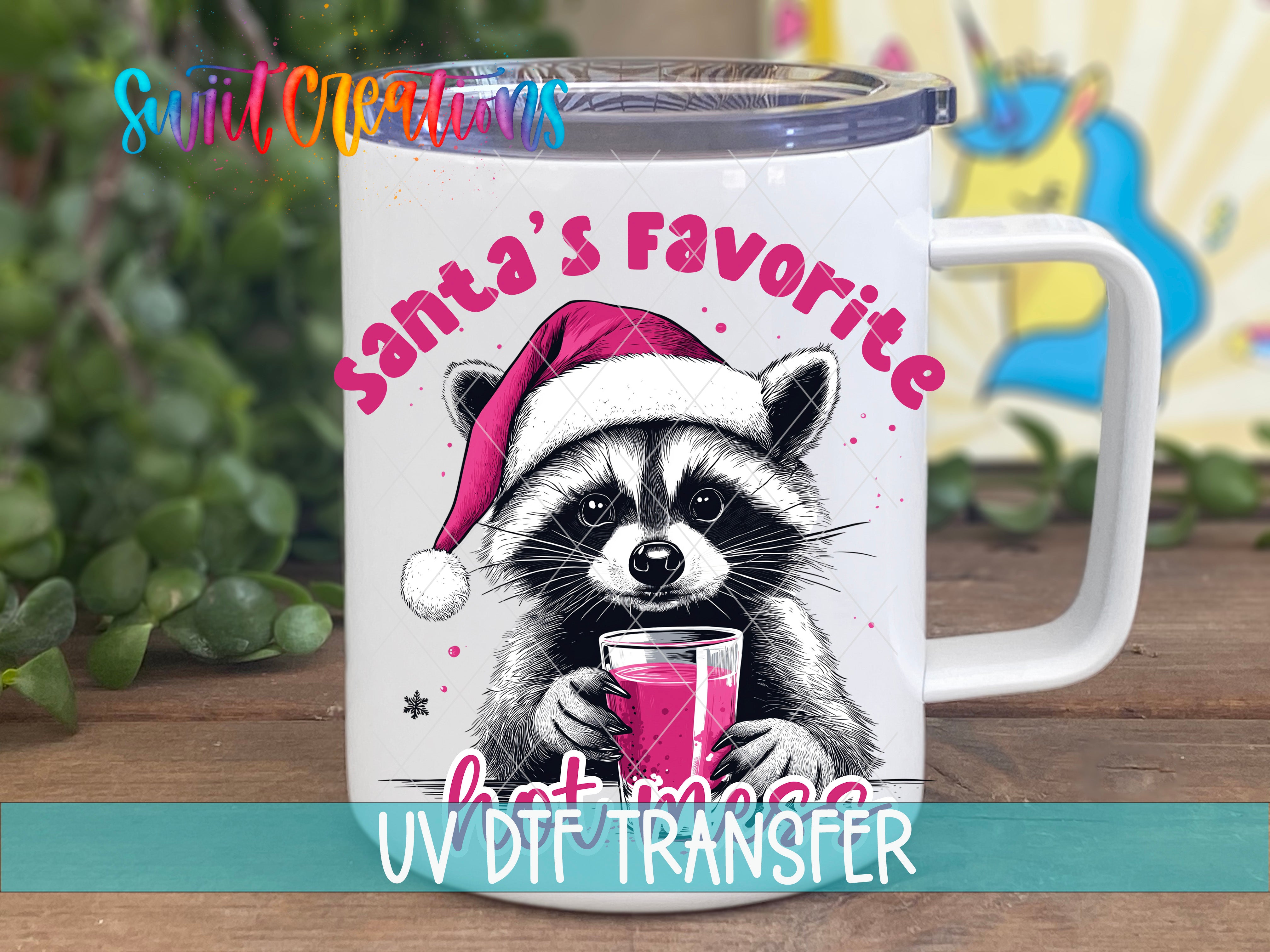 A mug with a raccoon wearing a Santa hat and holding a drink, with the text "Santa's Favorite" and "Hot Mess" printed on it.