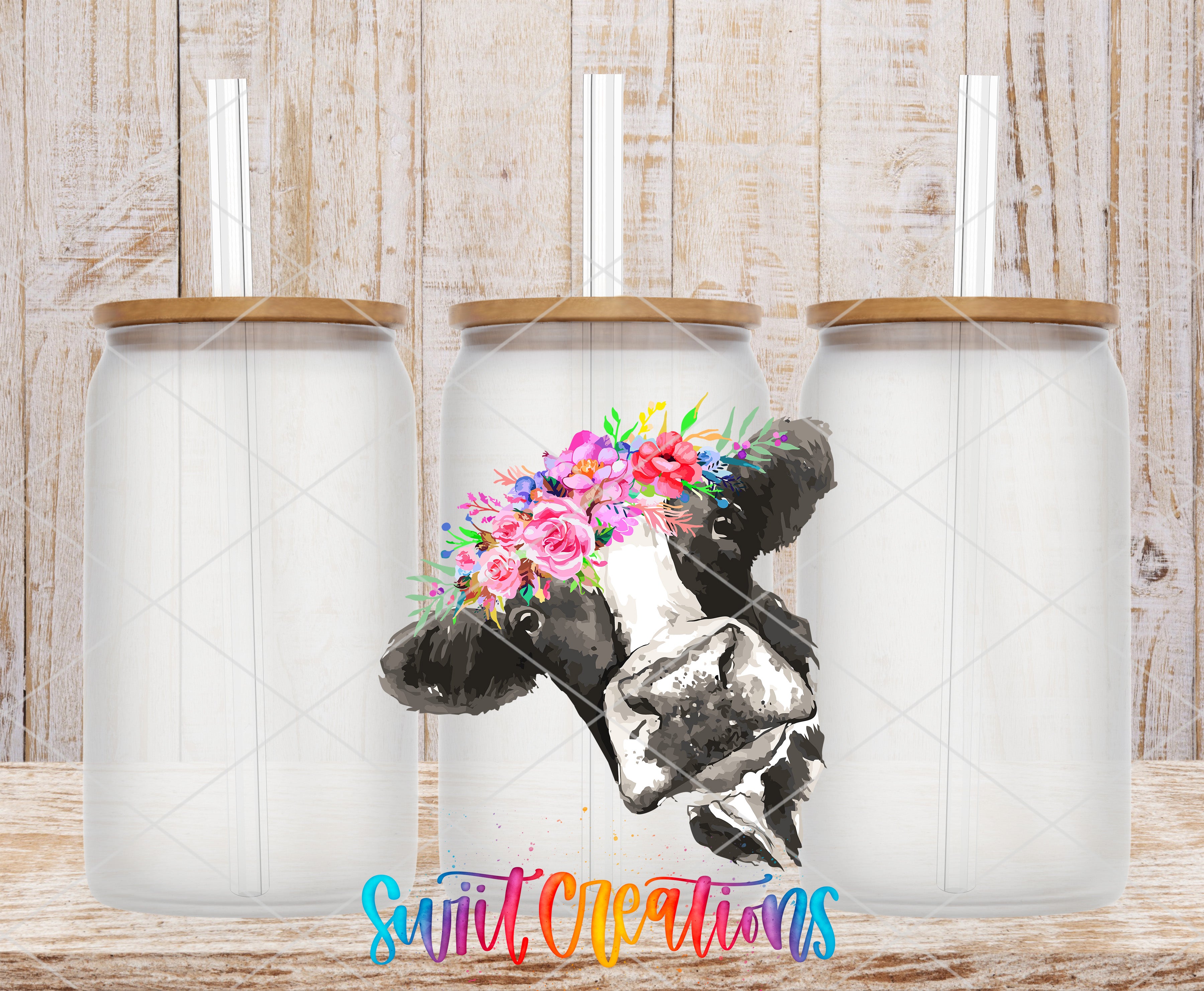 three glass jars with lids, each containing a straw. The jars are arranged in a row, and there is a floral design on the front of one of the jars. The background is a wooden wall with a textured appearance.