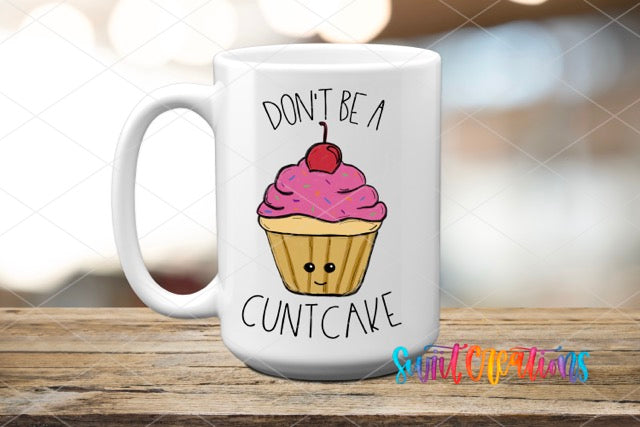 a white coffee mug with a pink frosted cupcake on it