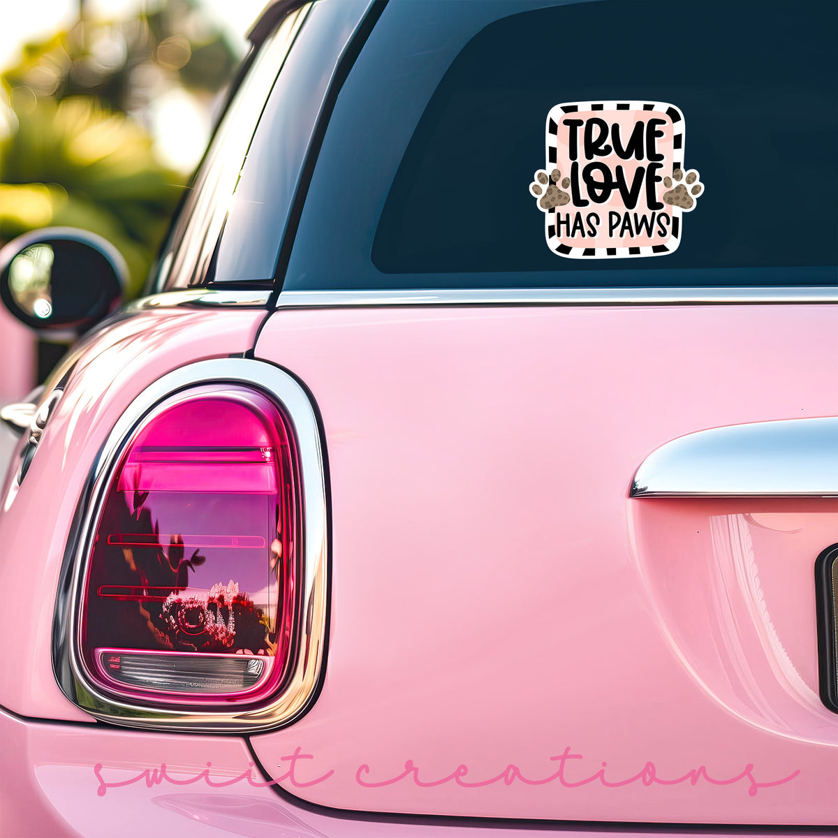 True Love Has Paws sticker on the back window of a pink car