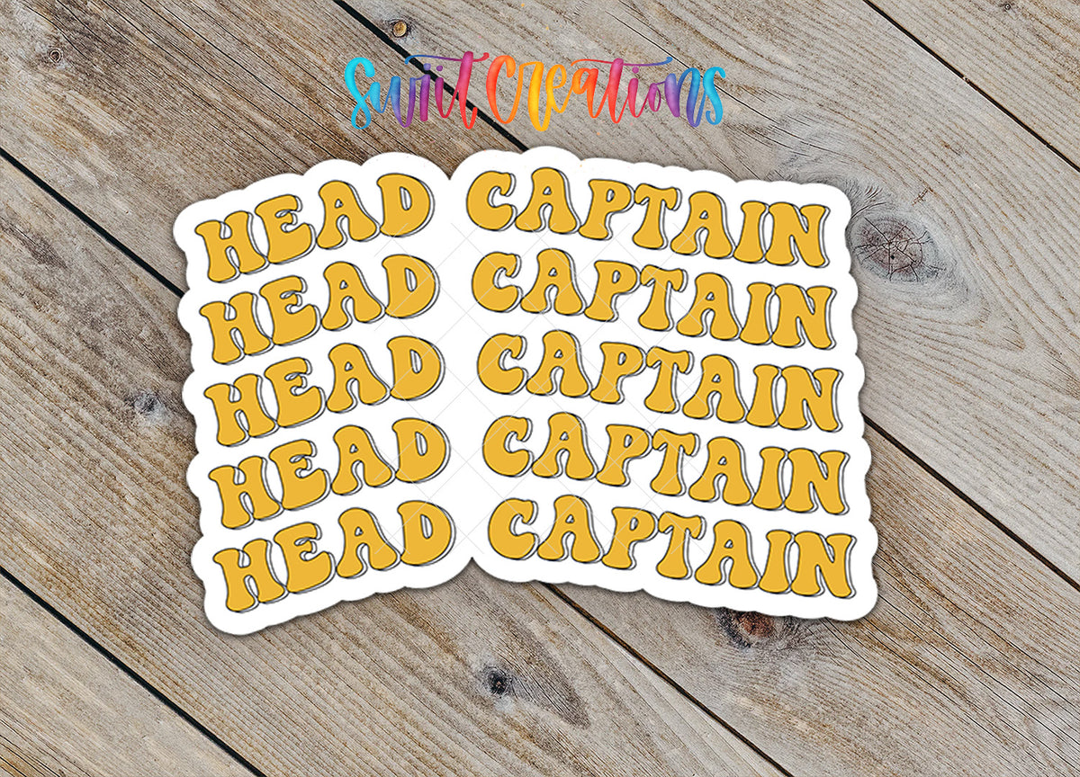 Stickers with the text "HEAD CAPTAIN" in a stylized font, arranged on a wooden surface.