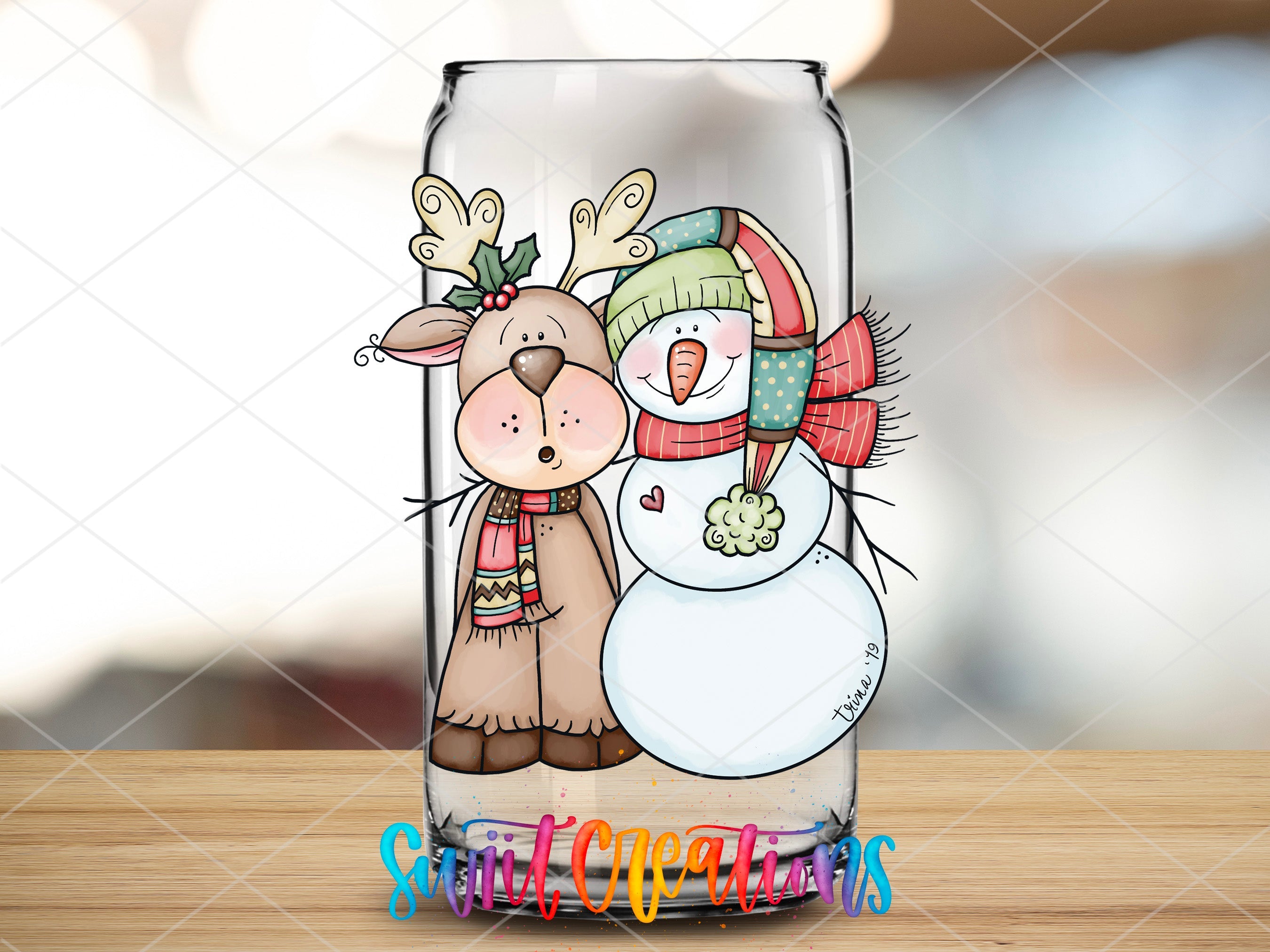 a glass with a picture of a snowman and a reindeer