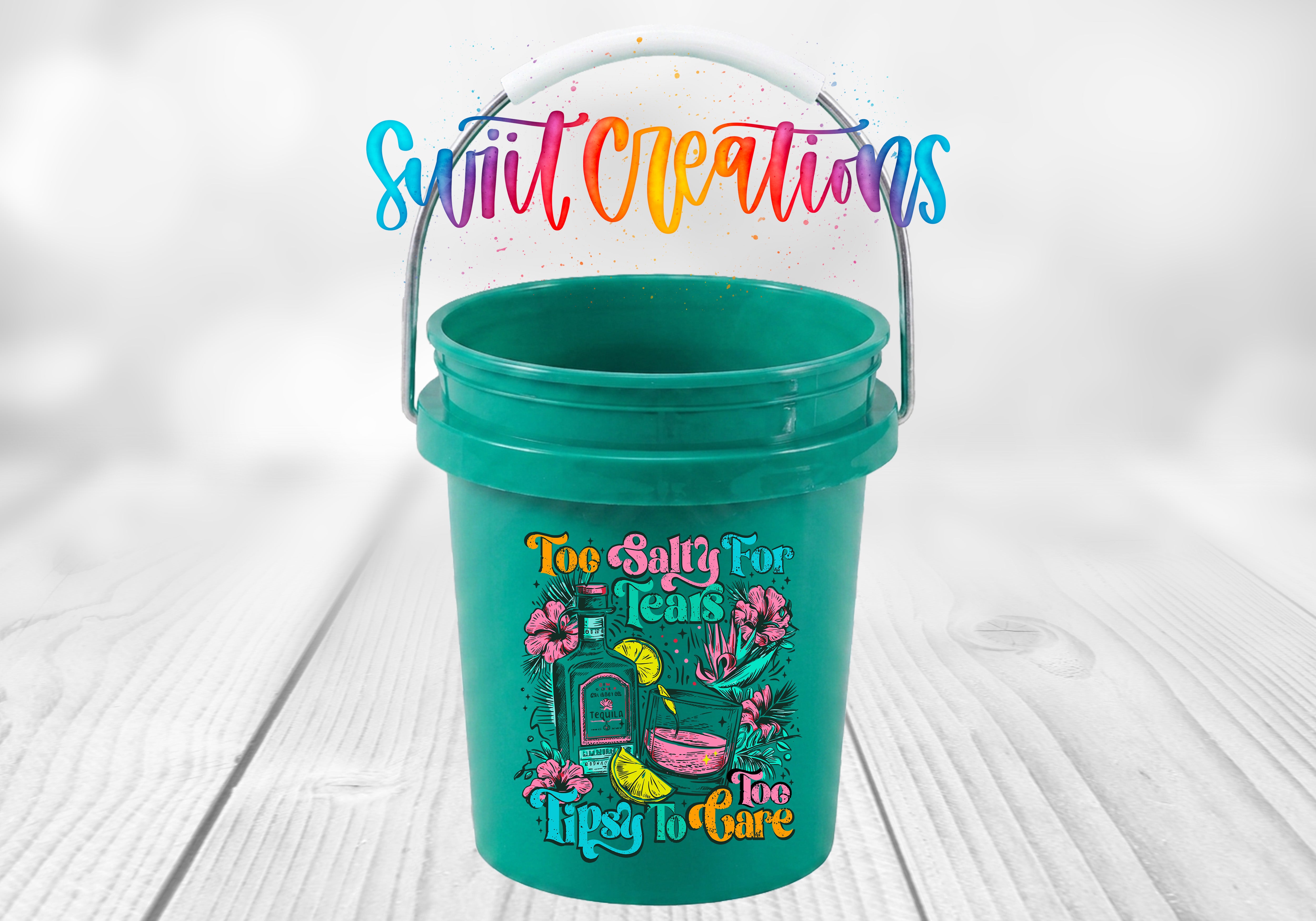 A green bucket with a colorful design and text printed on it, placed on a wooden surface.