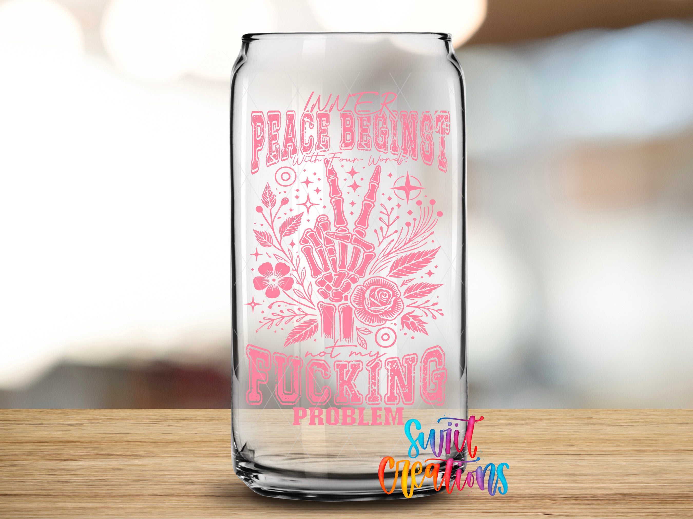 A glass can with a pink and white design featuring a hand making a peace sign and the text "Peace begins with a F*cking problem" printed on it.