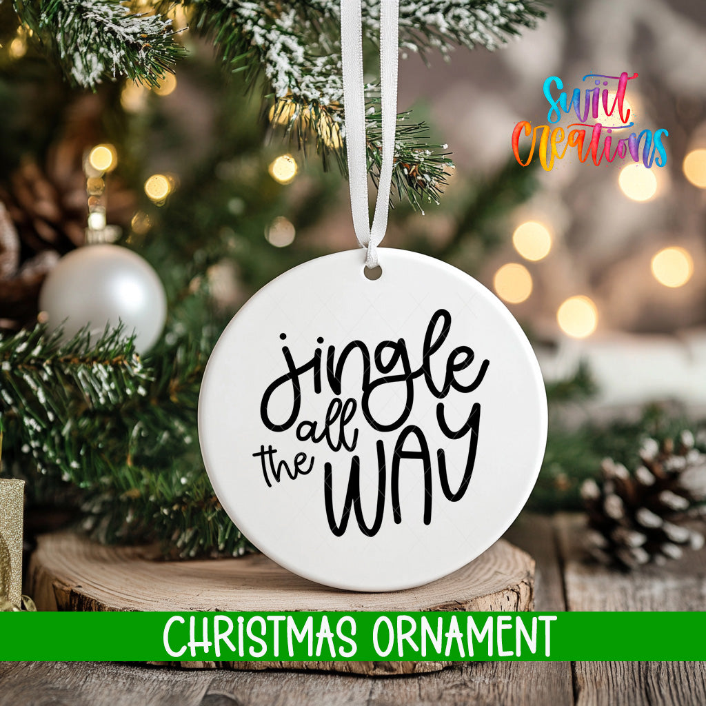 A white Christmas ornament with the text "Jingle all the way" hanging from a tree branch.