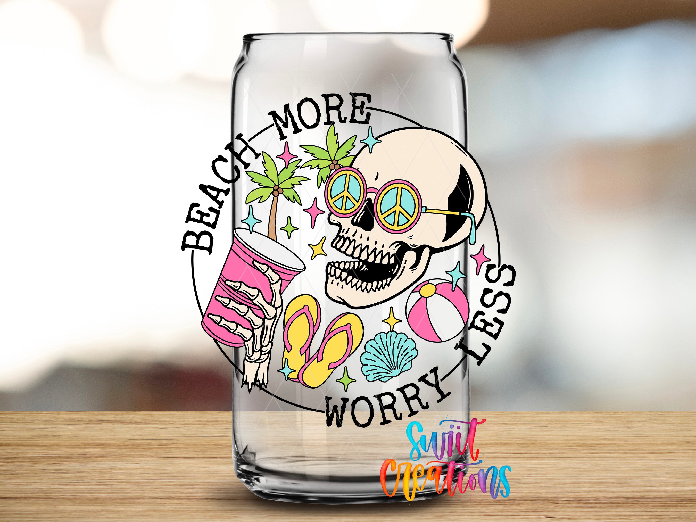 A glass with a colorful design featuring a skull, sunglasses, a peace sign, and beach-related items, along with the text "BEACH MORE WORRY LESS" and "Sign it up for free".