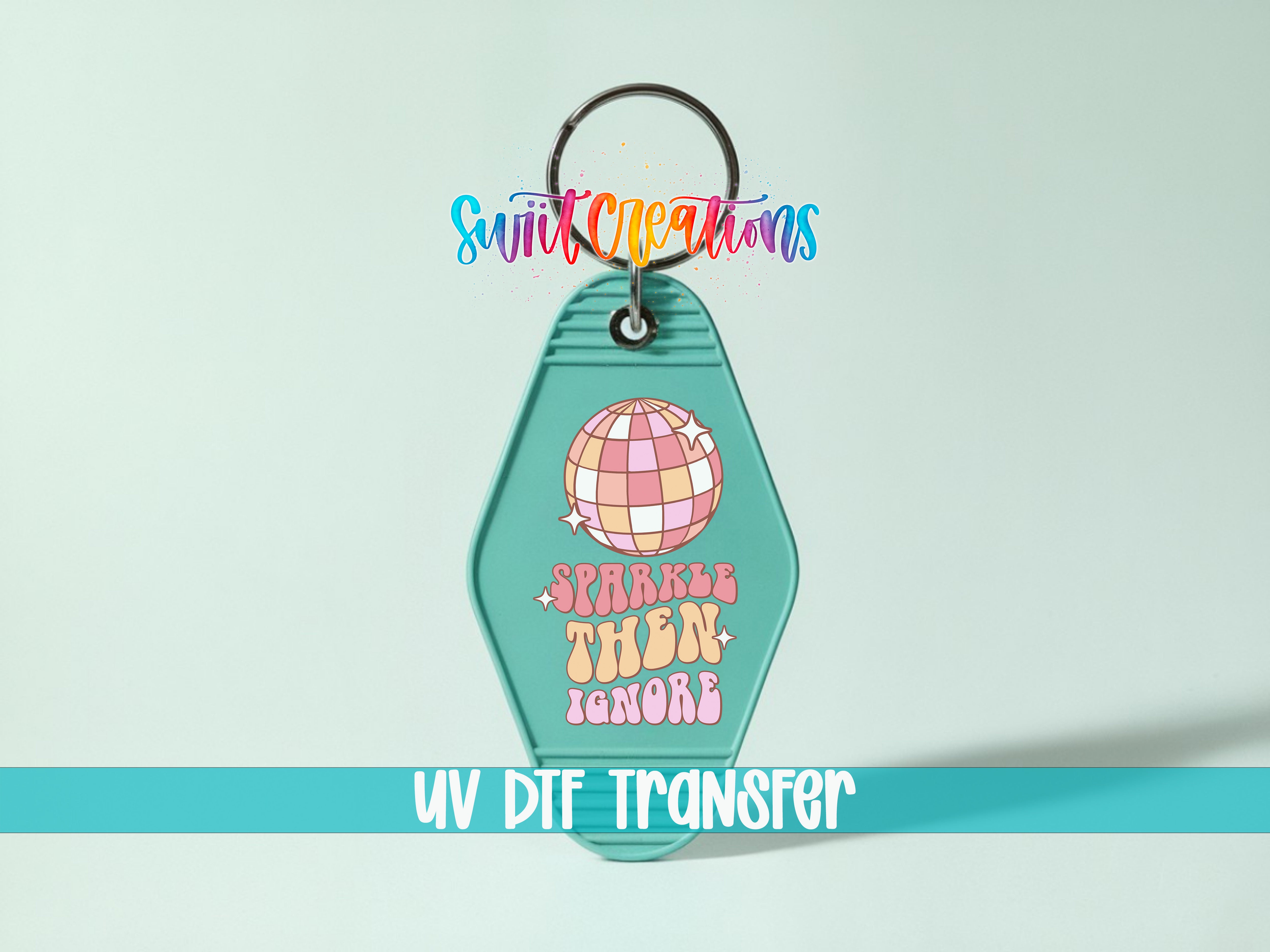 A keychain with a colorful design and text, including a disco ball and the phrase "Sparkle then ignore".