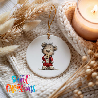 teddy bear holding a gingerbread cookie ceramic Christmas ornament styled on a cozy knit blanket