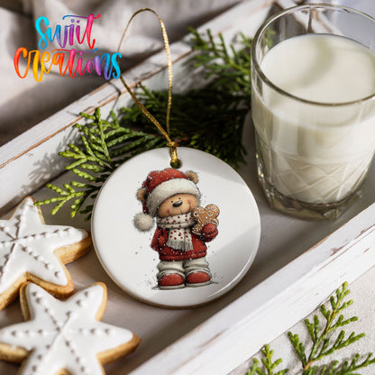 teddy bear in a Santa hat holding a gingerbread cookie ceramic Christmas ornament styled with holiday cookies and a candle