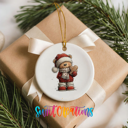 teddy bear in a Santa hat holding a gingerbread cookie ceramic Christmas ornament displayed on a wrapped Christmas gift