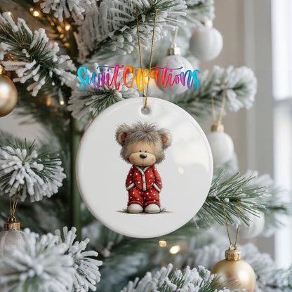 teddy bear wearing red Christmas pajamas ceramic Christmas ornament hanging on a frosted Christmas tree