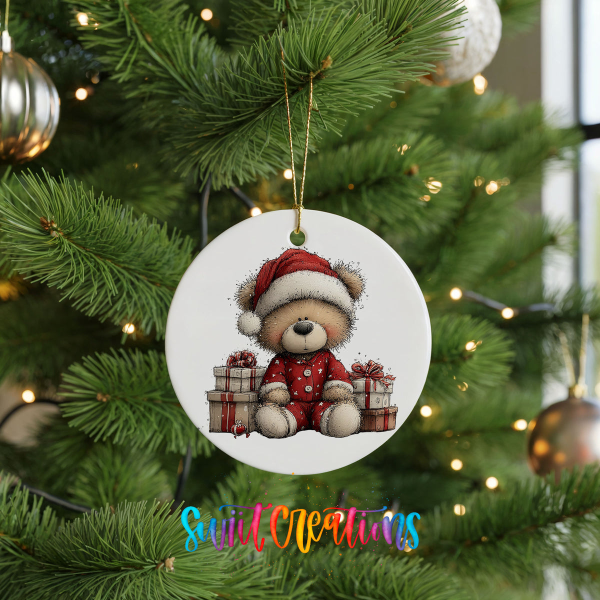 seated teddy bear with Christmas gifts ceramic Christmas ornament hanging on a lit Christmas tree
