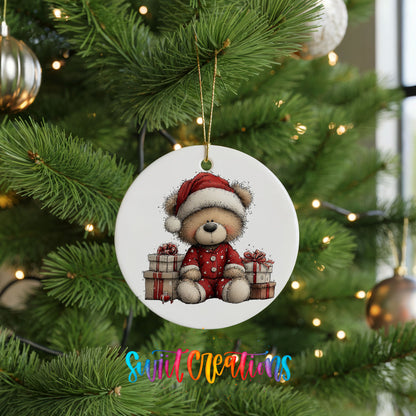 seated teddy bear with Christmas gifts ceramic Christmas ornament hanging on a lit Christmas tree