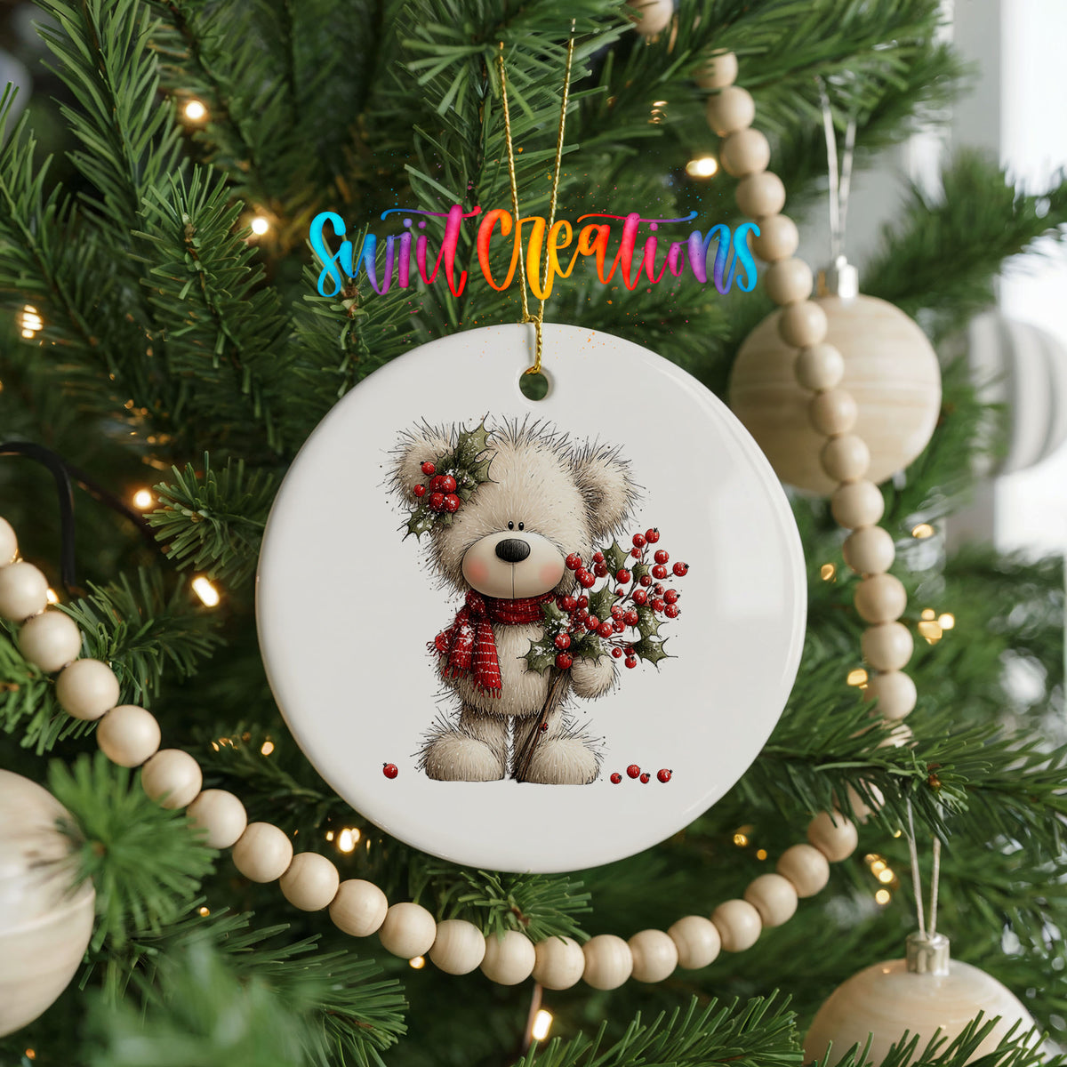 teddy bear with holly and red berries ceramic Christmas ornament hanging on a green Christmas tree