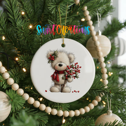 teddy bear with holly and red berries ceramic Christmas ornament hanging on a green Christmas tree
