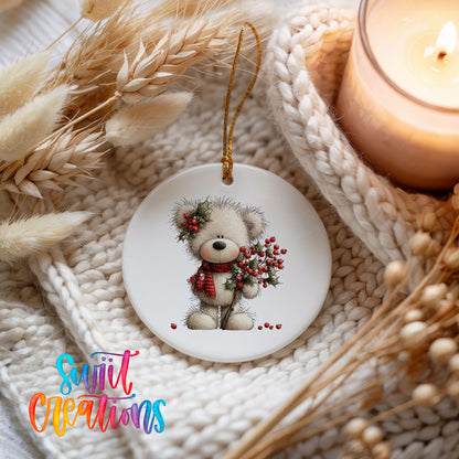 teddy bear with holly and red berries ceramic Christmas ornament styled on a cozy knit blanket